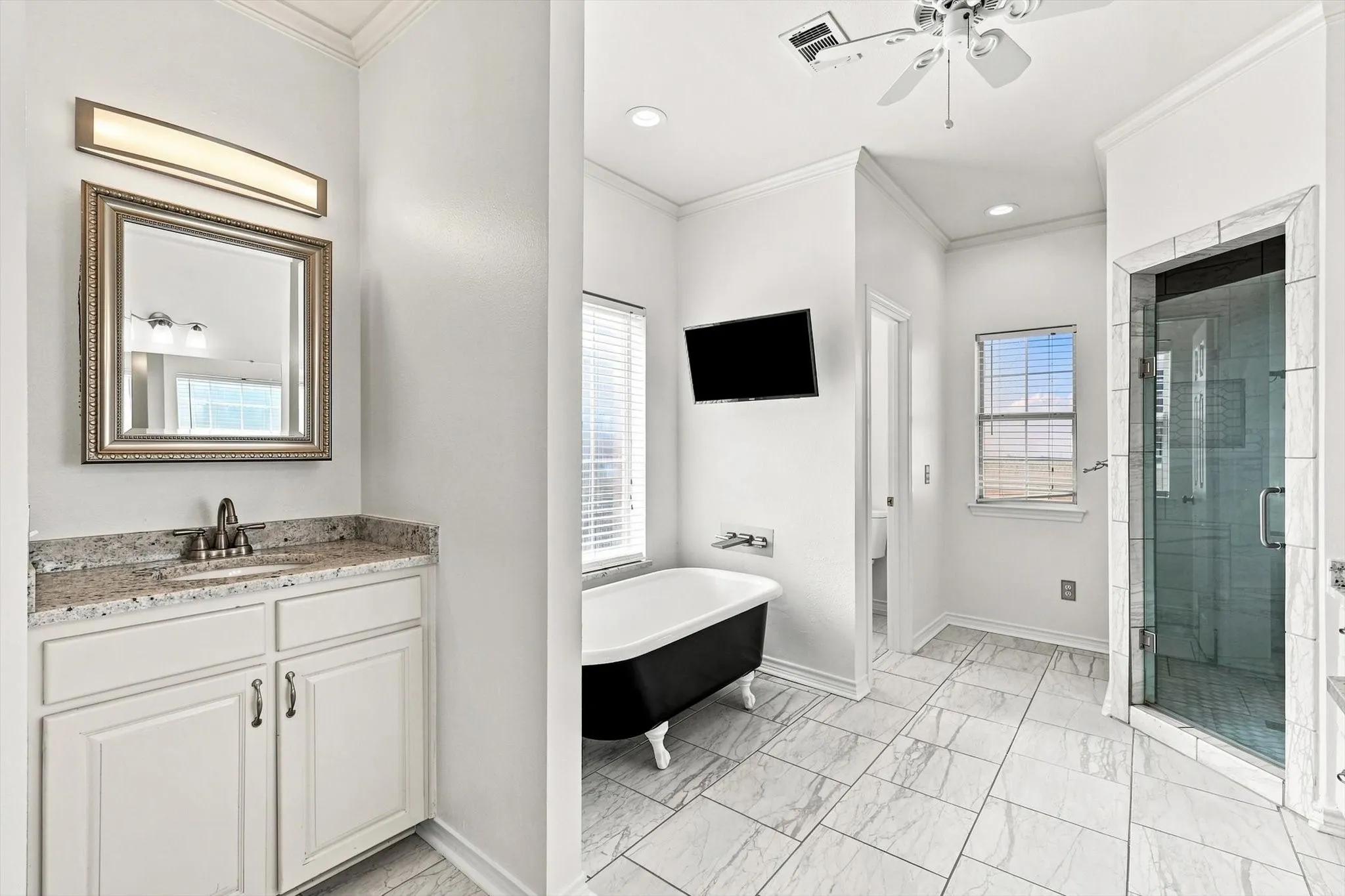 No knocking elbows in the spacious primary bath, single vanity shown here, with separate shower and love the latrine area with the door!  Soaking tub to relax and enjoy your show.