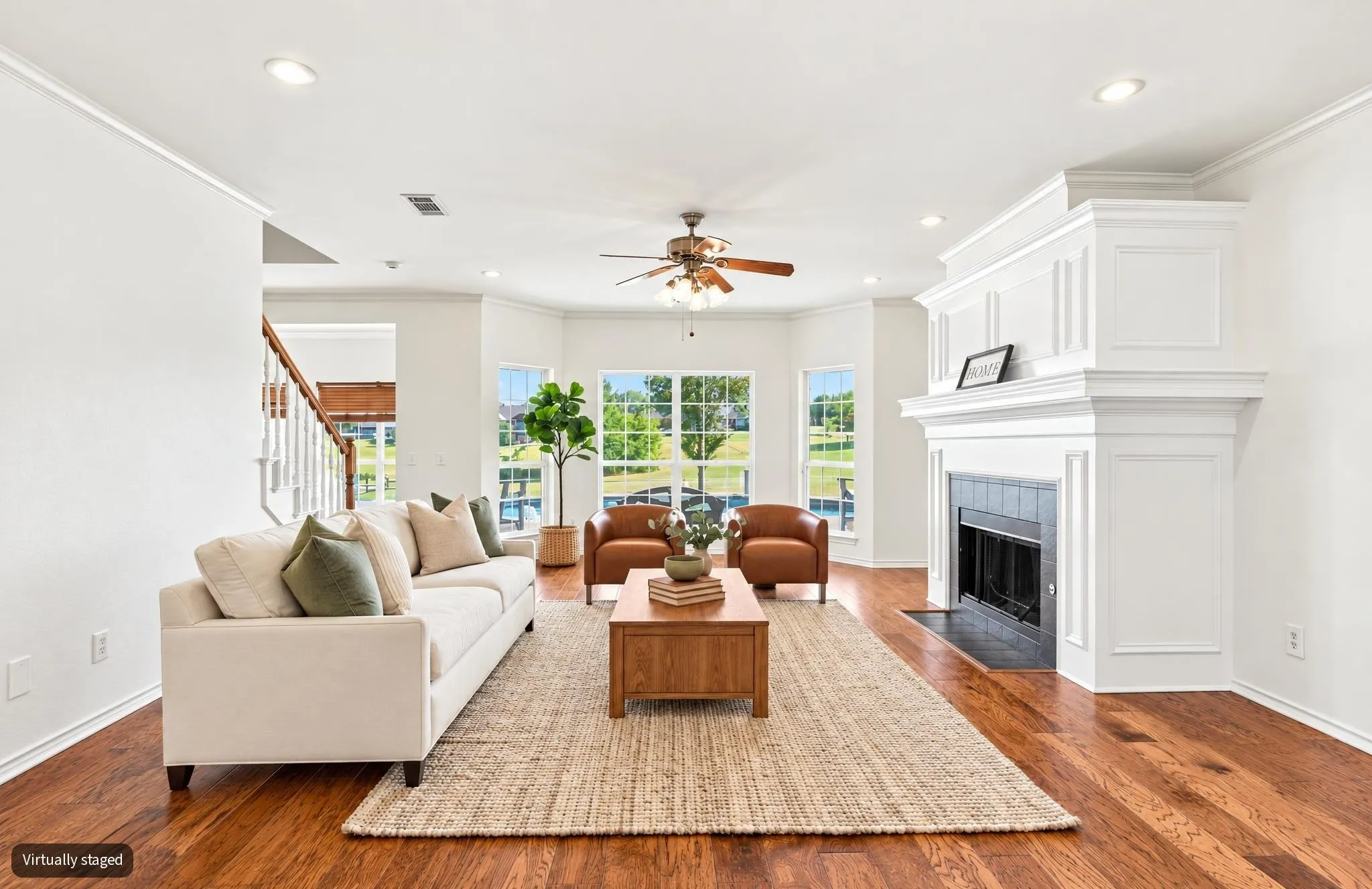 Virtually staged, Hardwood flooring throughout, white crown molding, recessed lighting, white wood-paneled fireplace, and bay windows