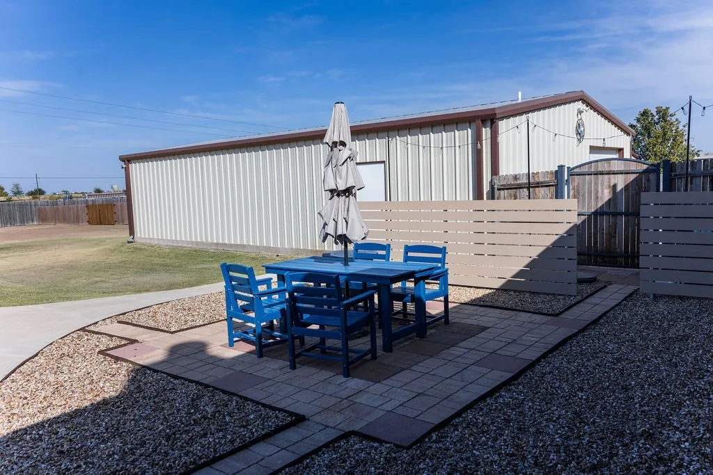 Brick exterior with a covered patio and a large concrete pathway.