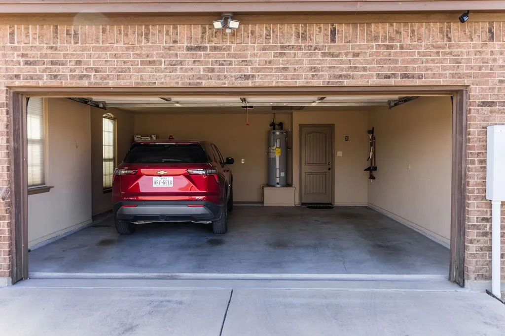 Attached two-car garage with a finished concrete floor and textured walls.