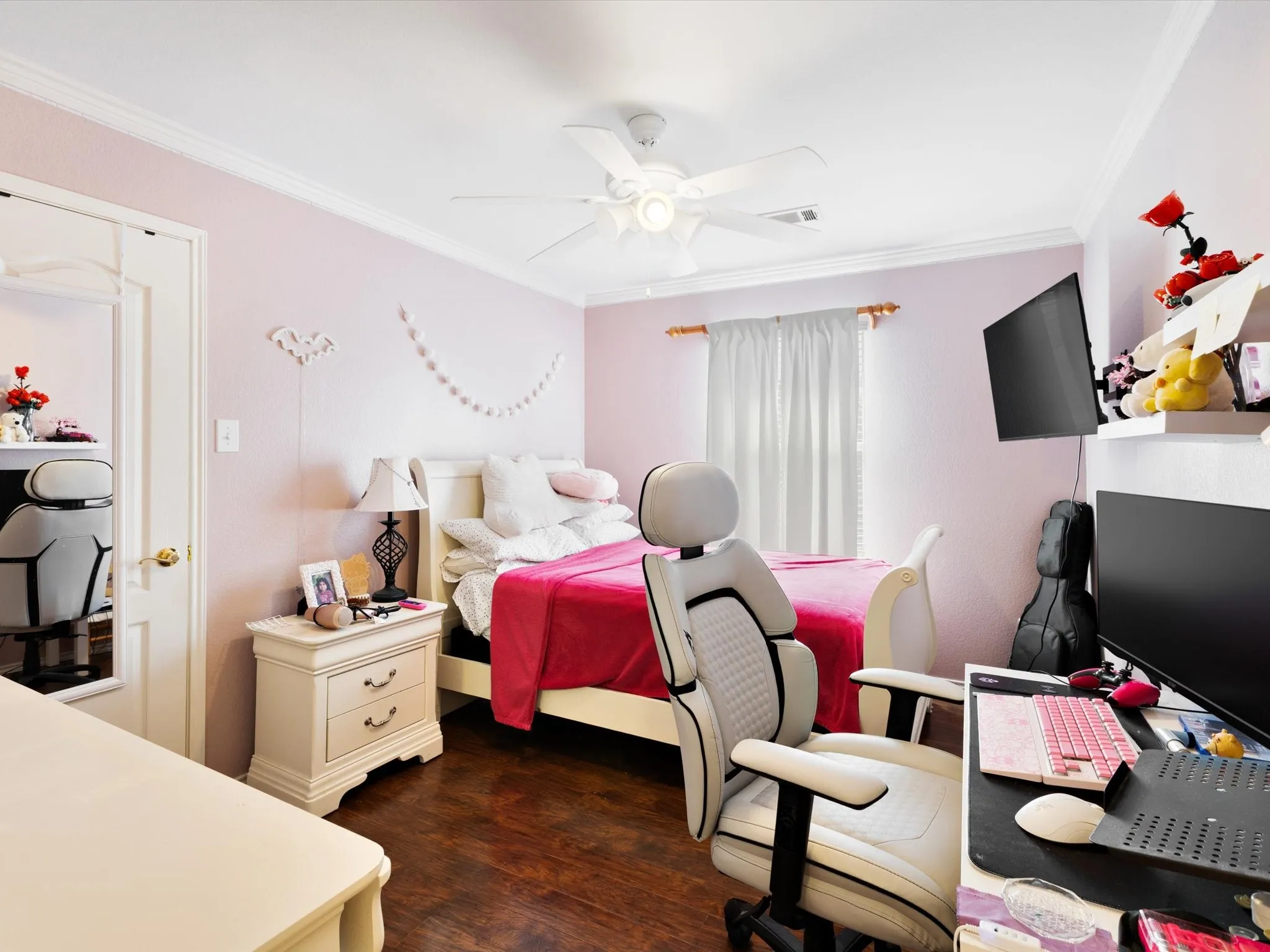 Hardwood-style flooring, a ceiling fan with integrated lighting, and crown molding