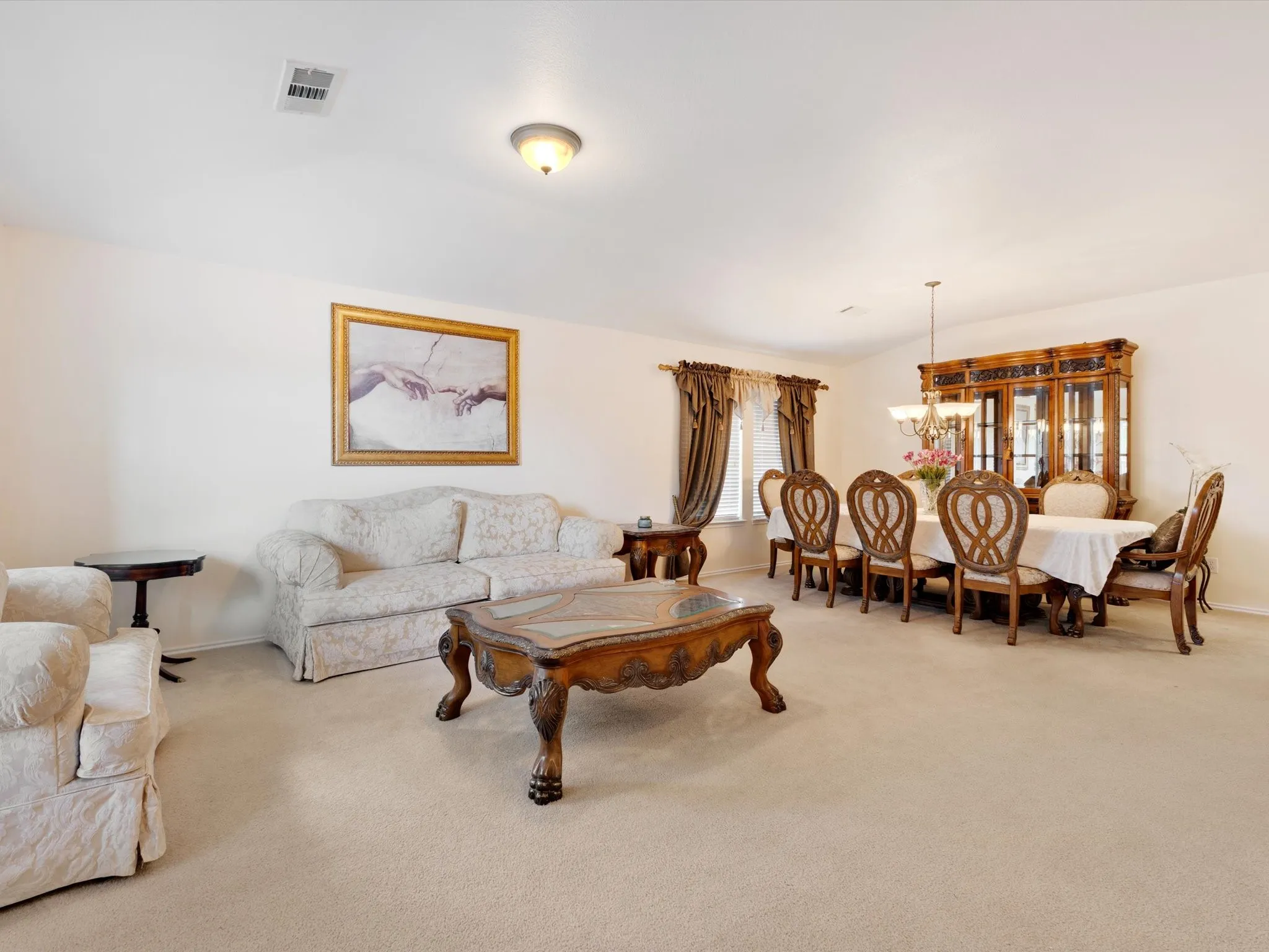 Recessed lighting, wall-to-wall carpeting, and a chandelier illuminate the space