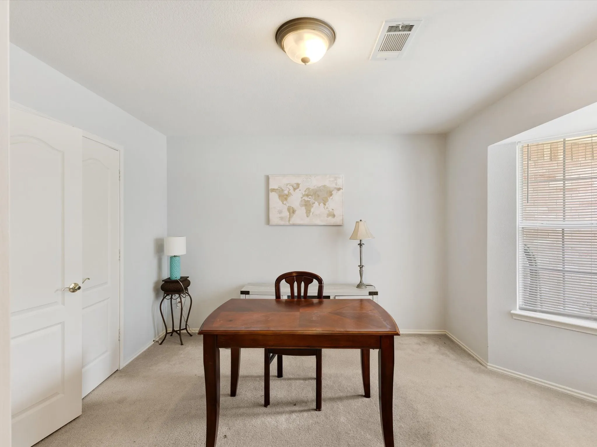 Recessed window with blinds, light-toned carpeting, and a flush-mount ceiling light fixture
