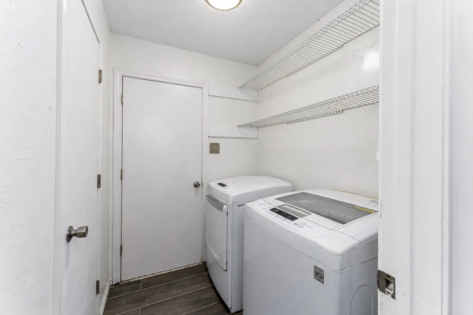 Dedicated laundry area with tile flooring and multiple white doors