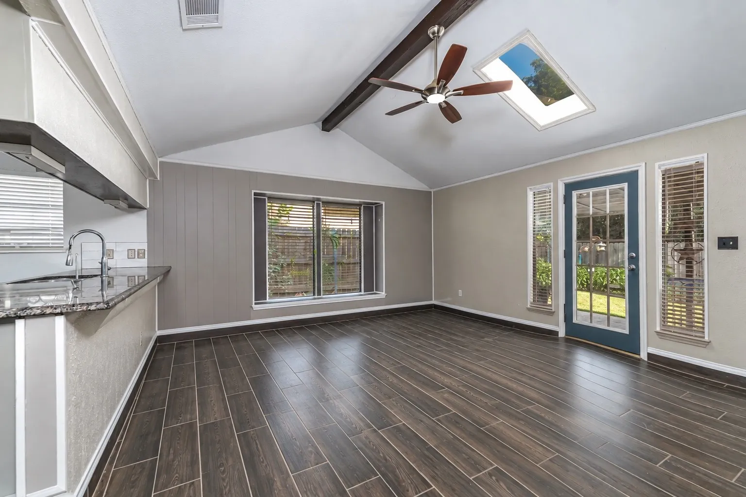 Open concept step-down living room with a vaulted ceiling and integrated skylight.