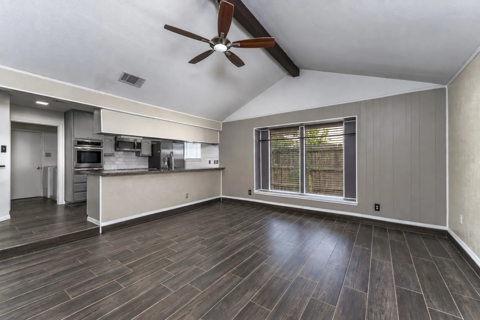 Open concept step-down living room with a vaulted ceiling and integrated skylight.