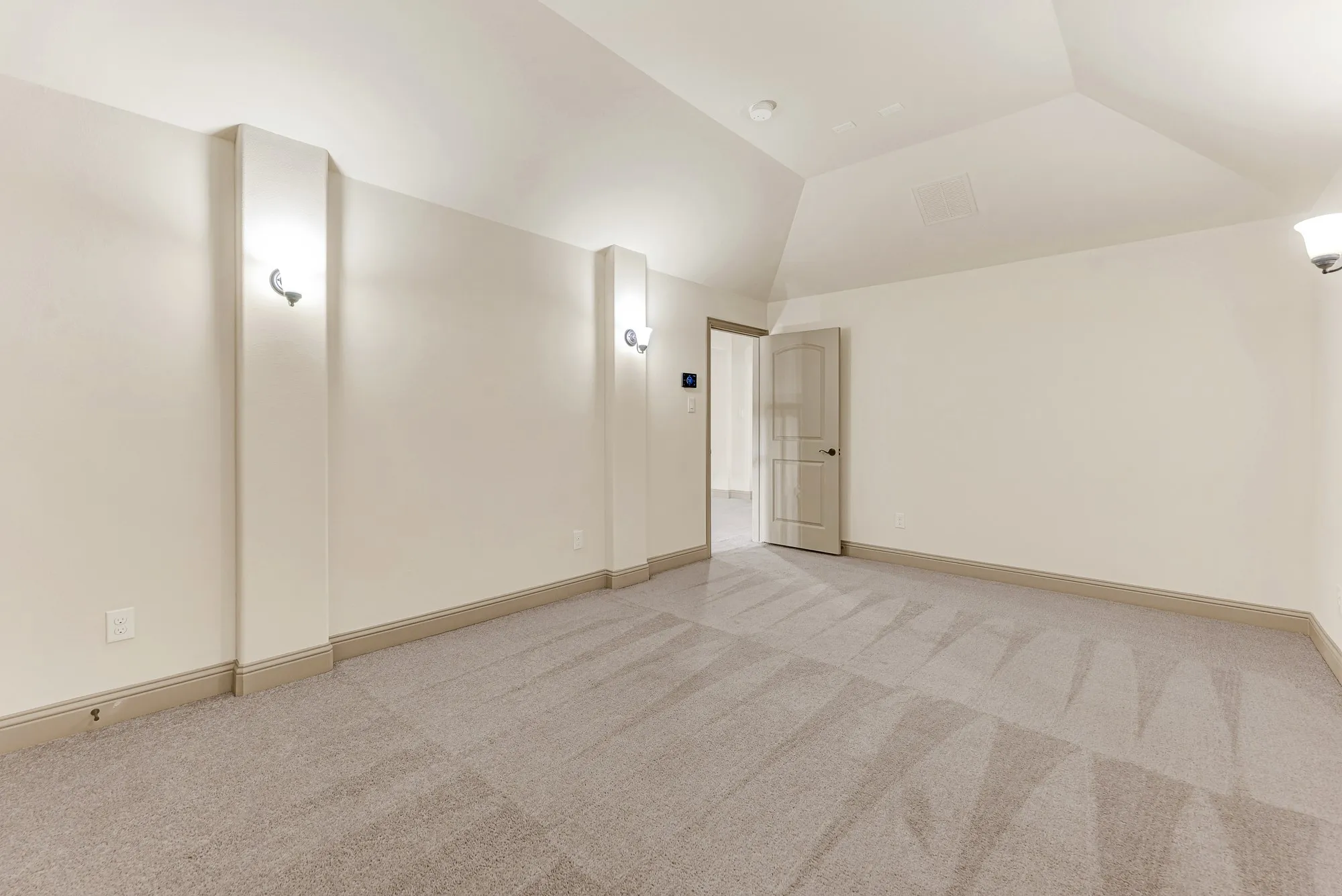 Windowless perimeter walls and upward-angled ceilings create an intimate, enclosed entertainment haven free from glare. It is tailored for late-night gaming sessions or screening new film releases in cozy, cinematic quiet.