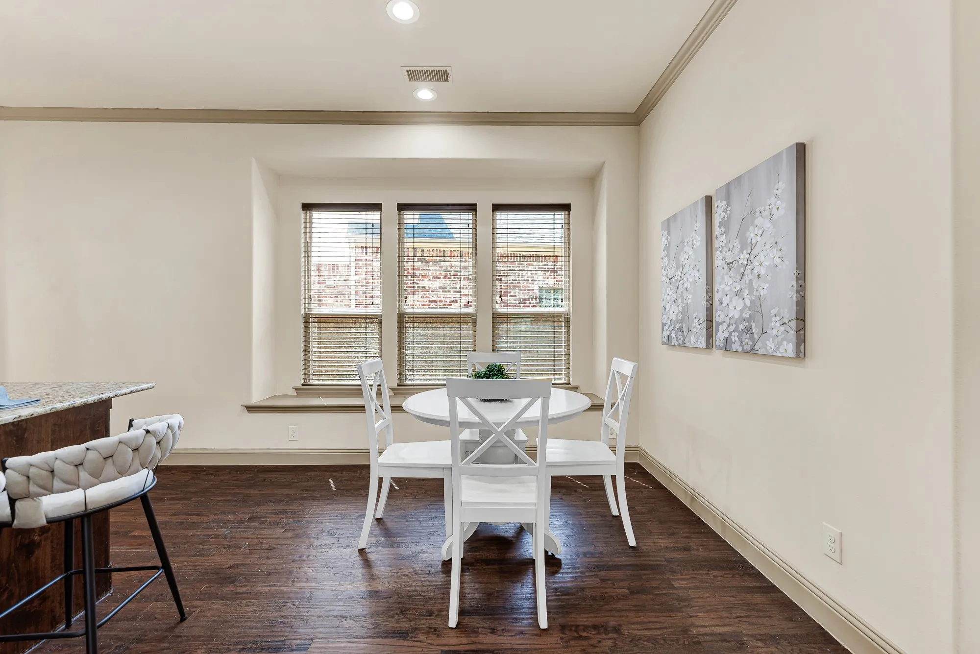 A deep picture ledge frames a trio of multi-pane windows, channeling bright exterior illumination directly into the casual dining enclave. Envision peaceful weekday breakfasts here, sipping hot tea while reviewing the morning paper in gentle sun.