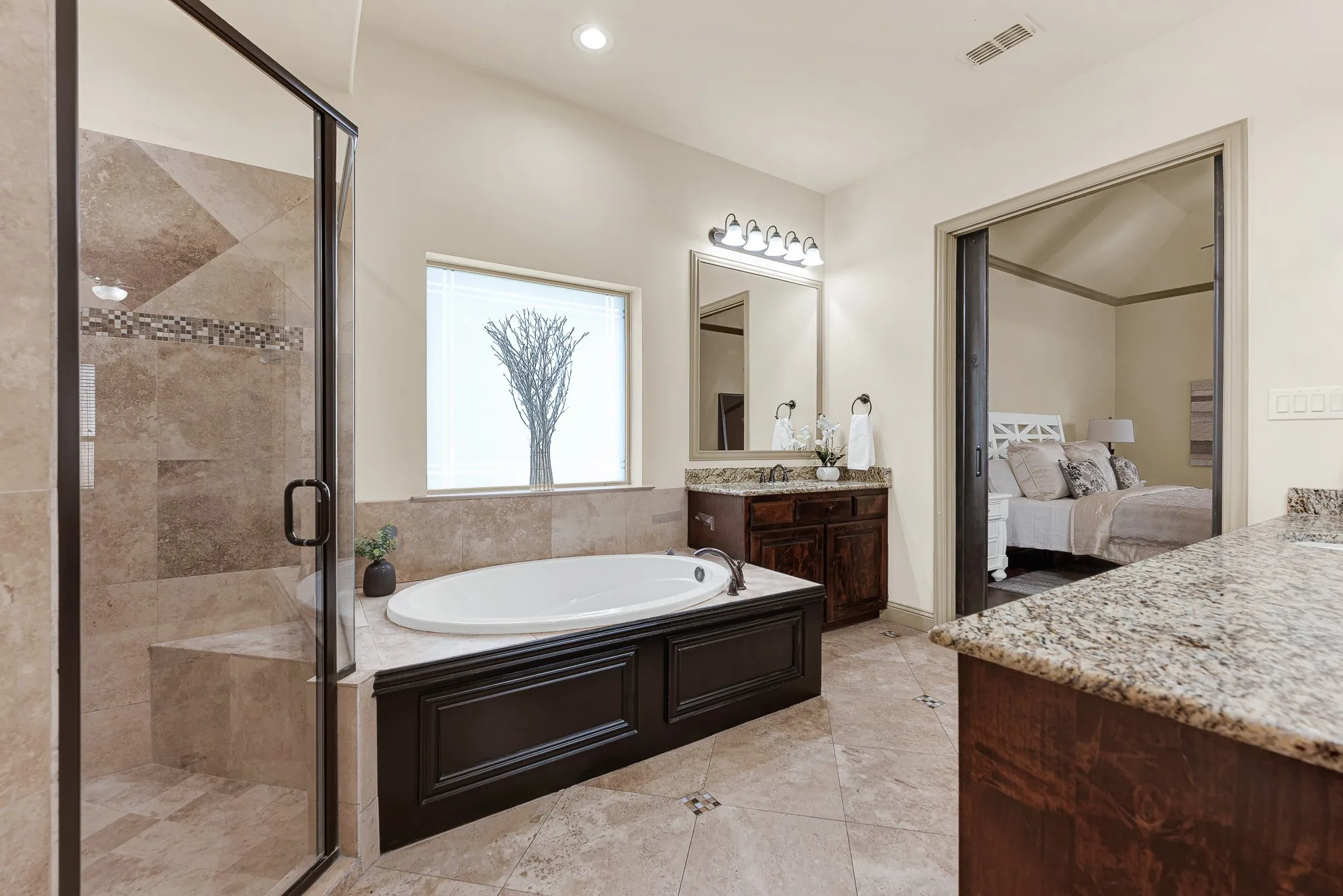 A paneled wainscot surround encases the deep drop-in garden tub, bathed in soft daylight from the frosted privacy window. Unwind with an aromatherapy bubble bath here, soaking away tension while surrounded by spa-inspired serenity.