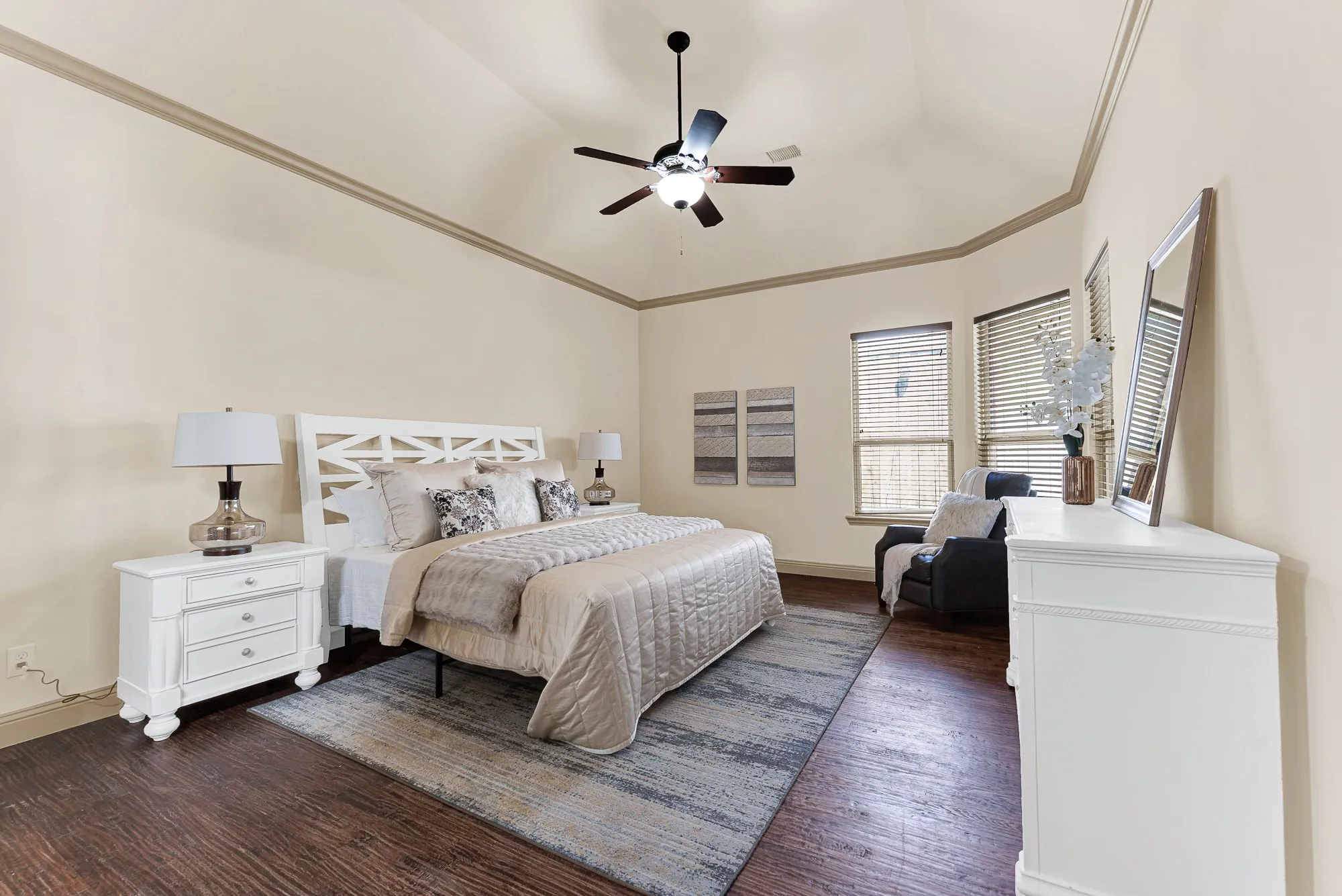 A dramatic vaulted ceiling rises above crisp perimeter crown molding, amplifying the sense of openness and airiness. It invites restful, slow mornings spent sleeping in and waking gently under soft overhead light.