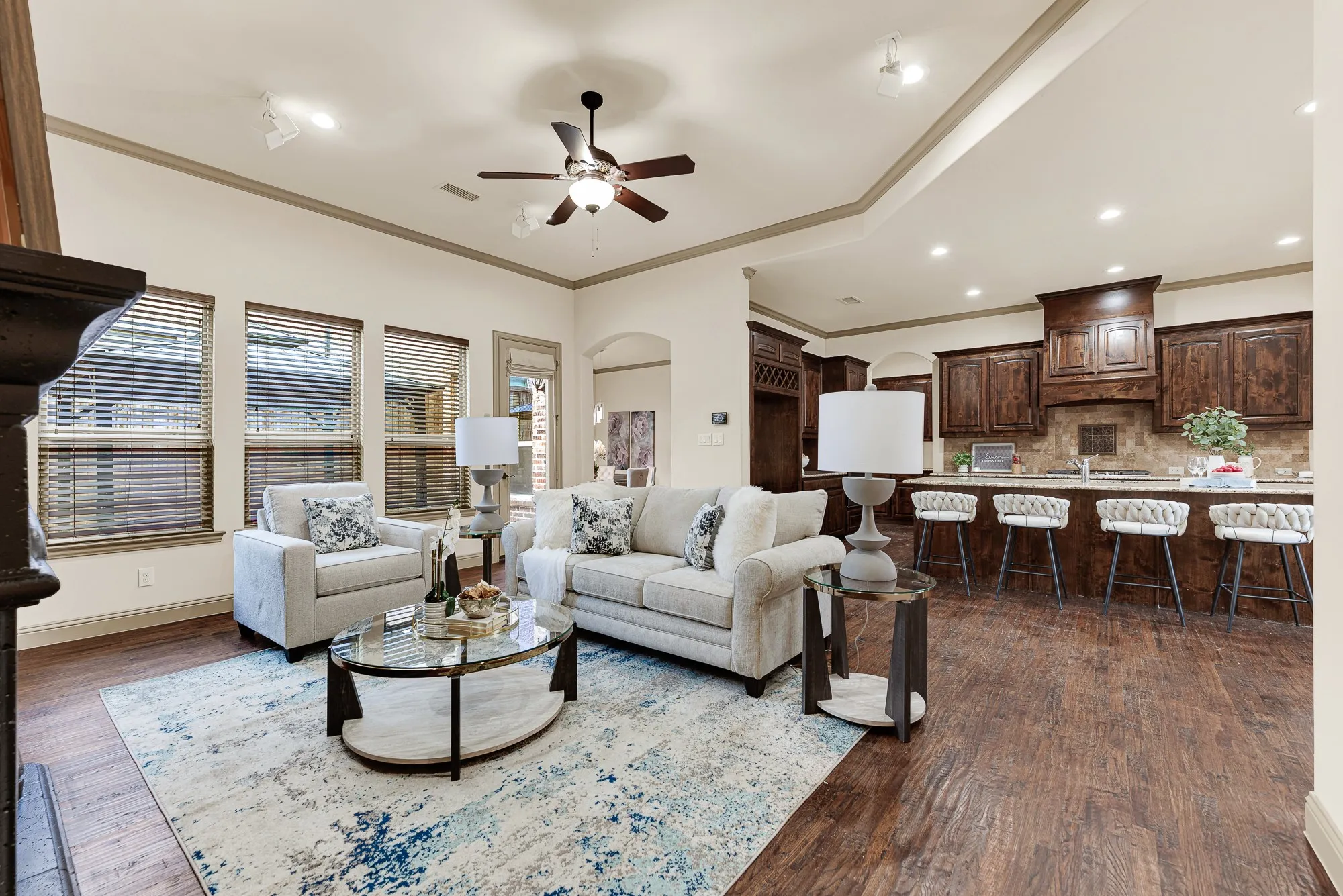 The open plan flows into the kitchen, illuminated by recessed fixtures that define distinct living zones. It sets the scene for casual wine tastings and appetizers with friends as dinner finishes on the stove