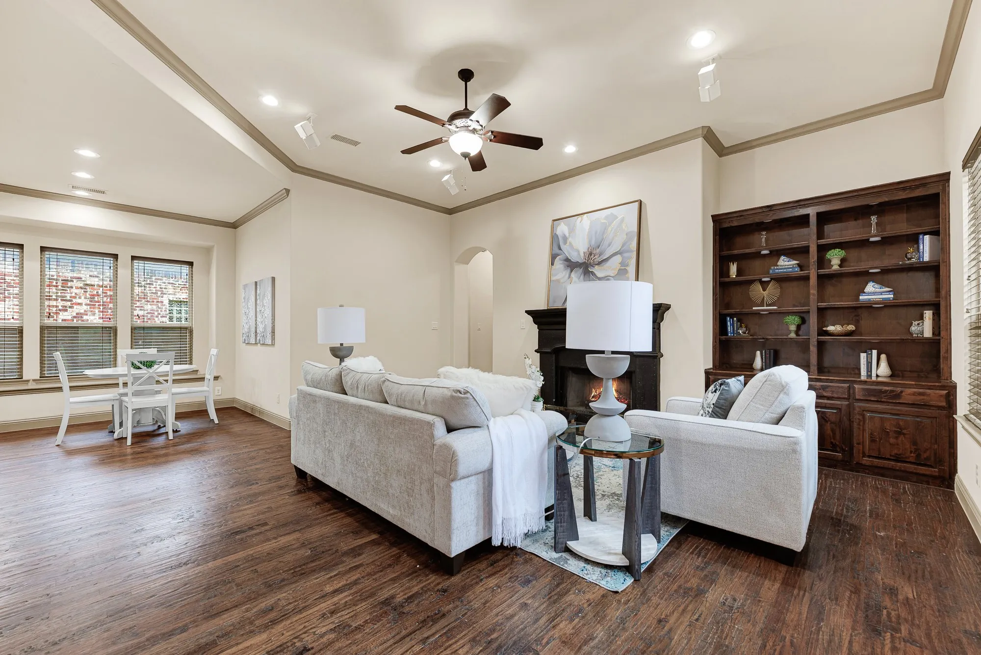 A grand dark hearth and tailored custom bookcase anchor the tall, coved ceiling with timeless character. Unwind here after a long day, curling up by the crackling fire with a favorite novel in hand.