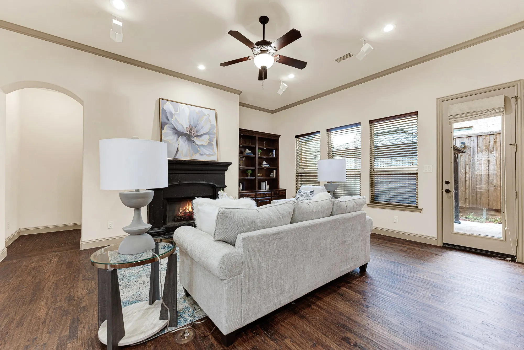Recessed art lighting highlights the clean wall profile, while the patio door offers easy outdoor access. It invites relaxed indoor-outdoor living, stepping directly out for fresh air between lively conversations.