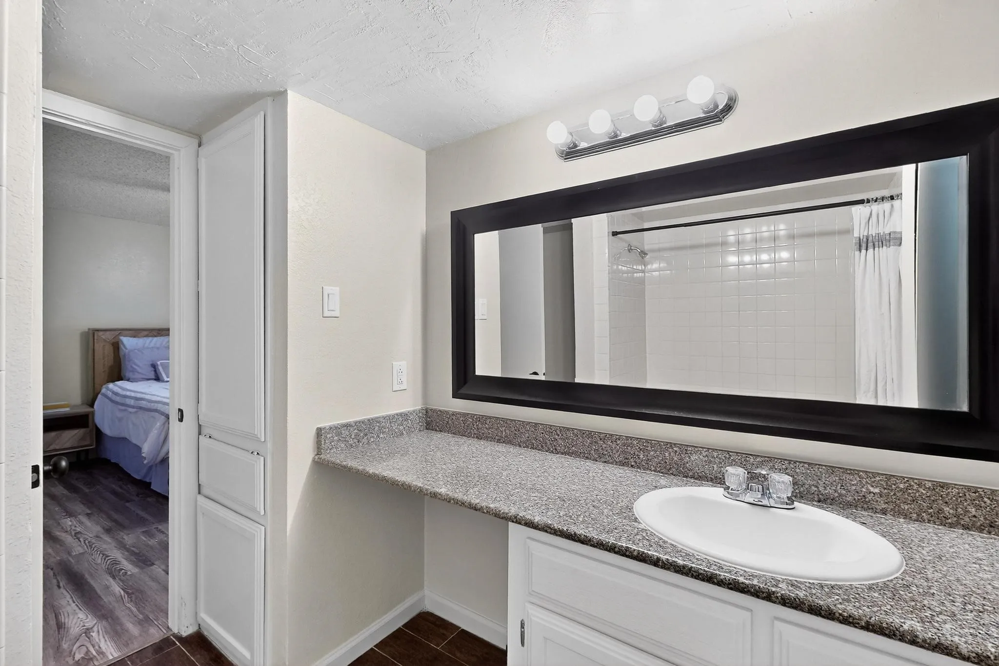 Bathroom vanity with an undermount sink, a chrome faucet, and a speckled countertop
