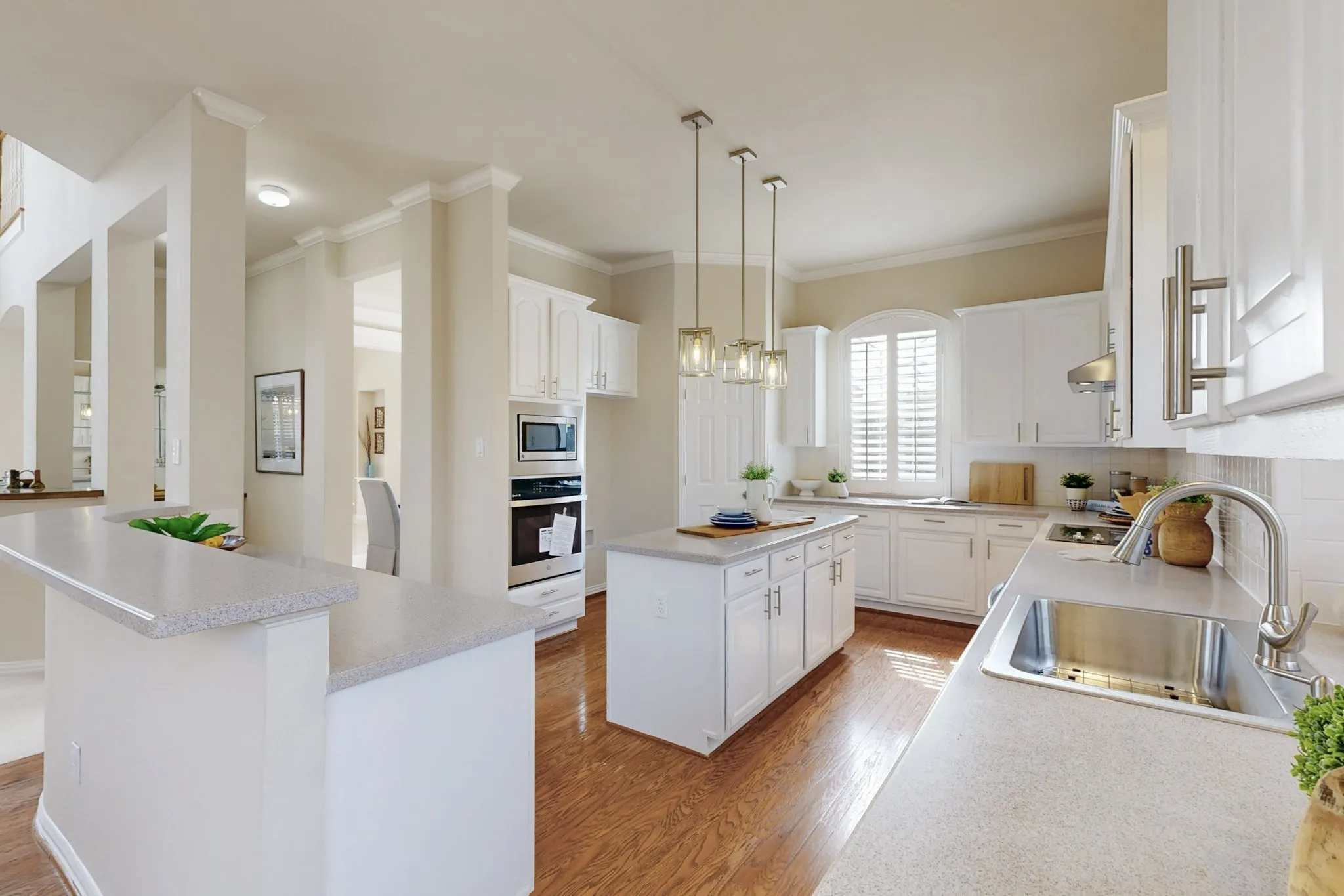 Open-concept kitchen featuring a center island, abundant cabinetry, hardwood floors, and elegant finishes designed for effortless entertaining