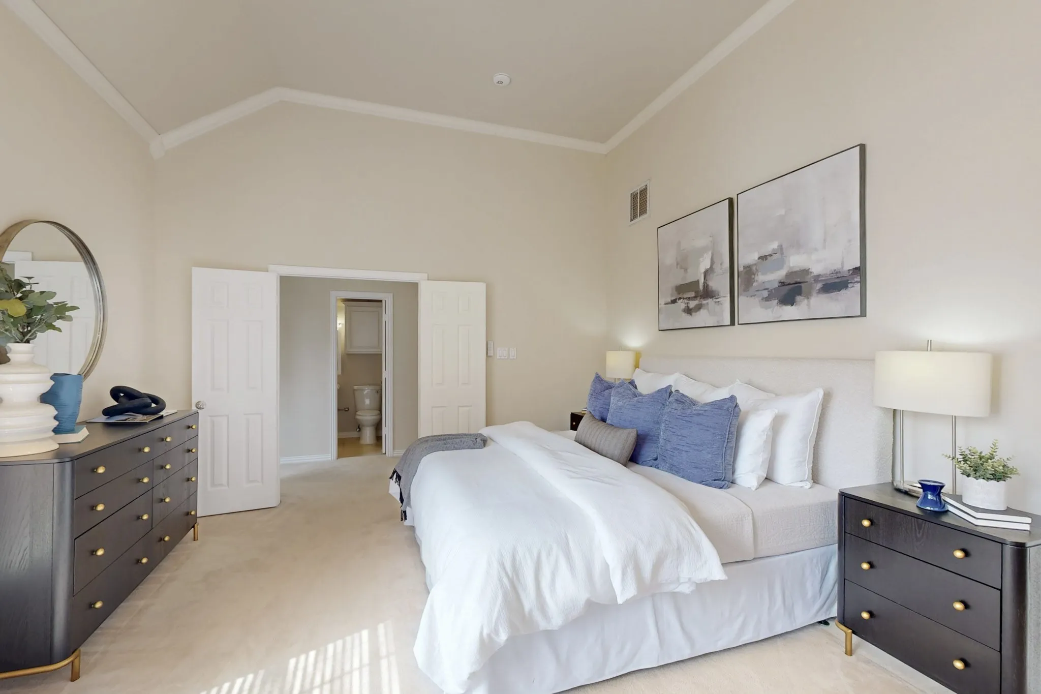 Spacious primary suite with vaulted ceilings, soft natural light, and a serene atmosphere designed for comfort and relaxation