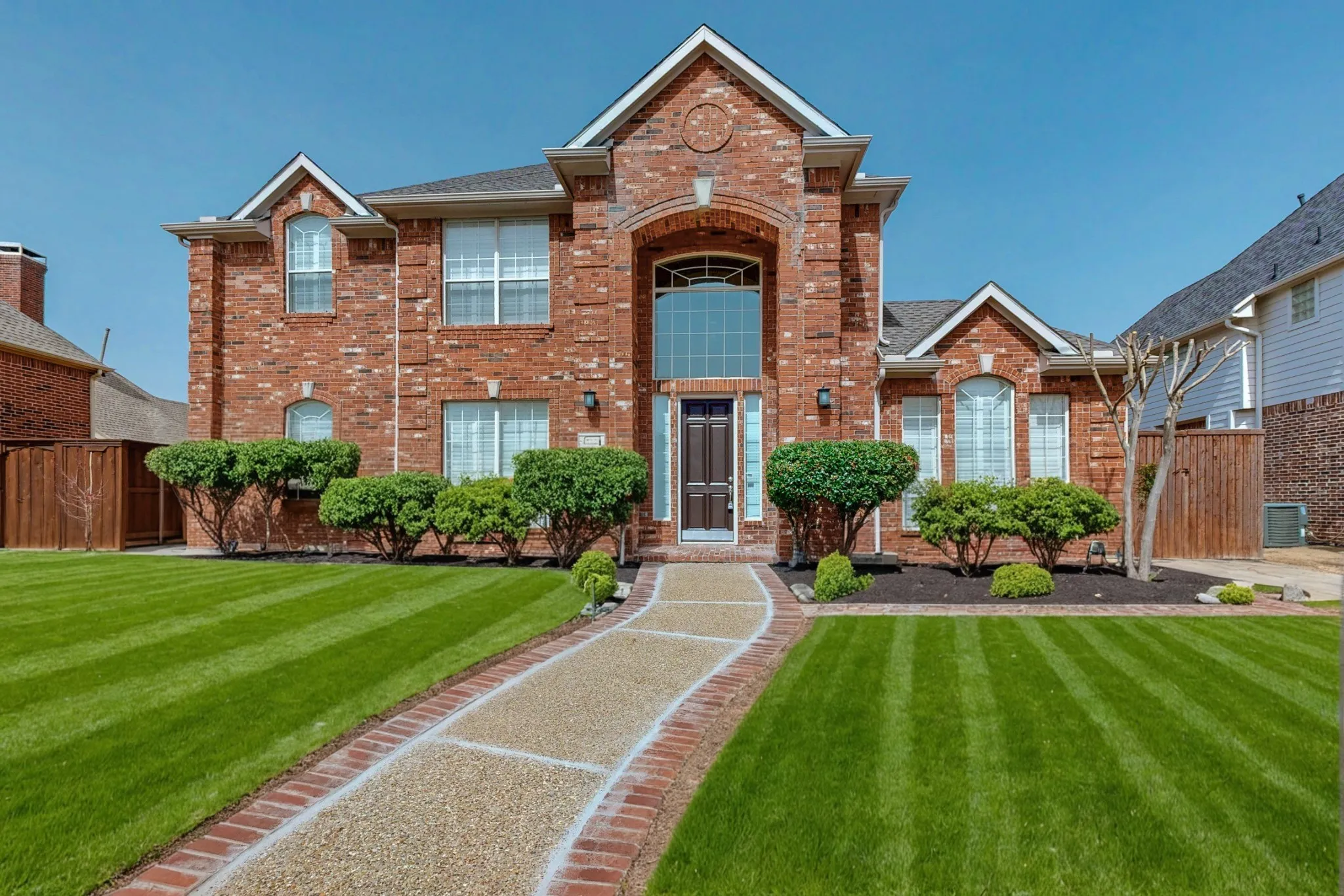 Stunning two-story home features a grand entry, manicured landscaping, and spacious living areas - Photos are from previous listing when home was staged.