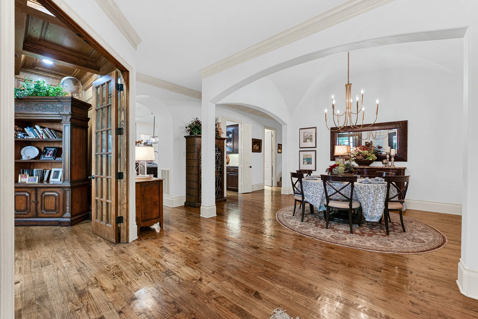 Graceful wide arches open the dining area directly to adjacent hallways and office with traditional French doors. Visualize welcoming dinner guests through the foyer, seamlessly transitioning into an evening of lively conversation.