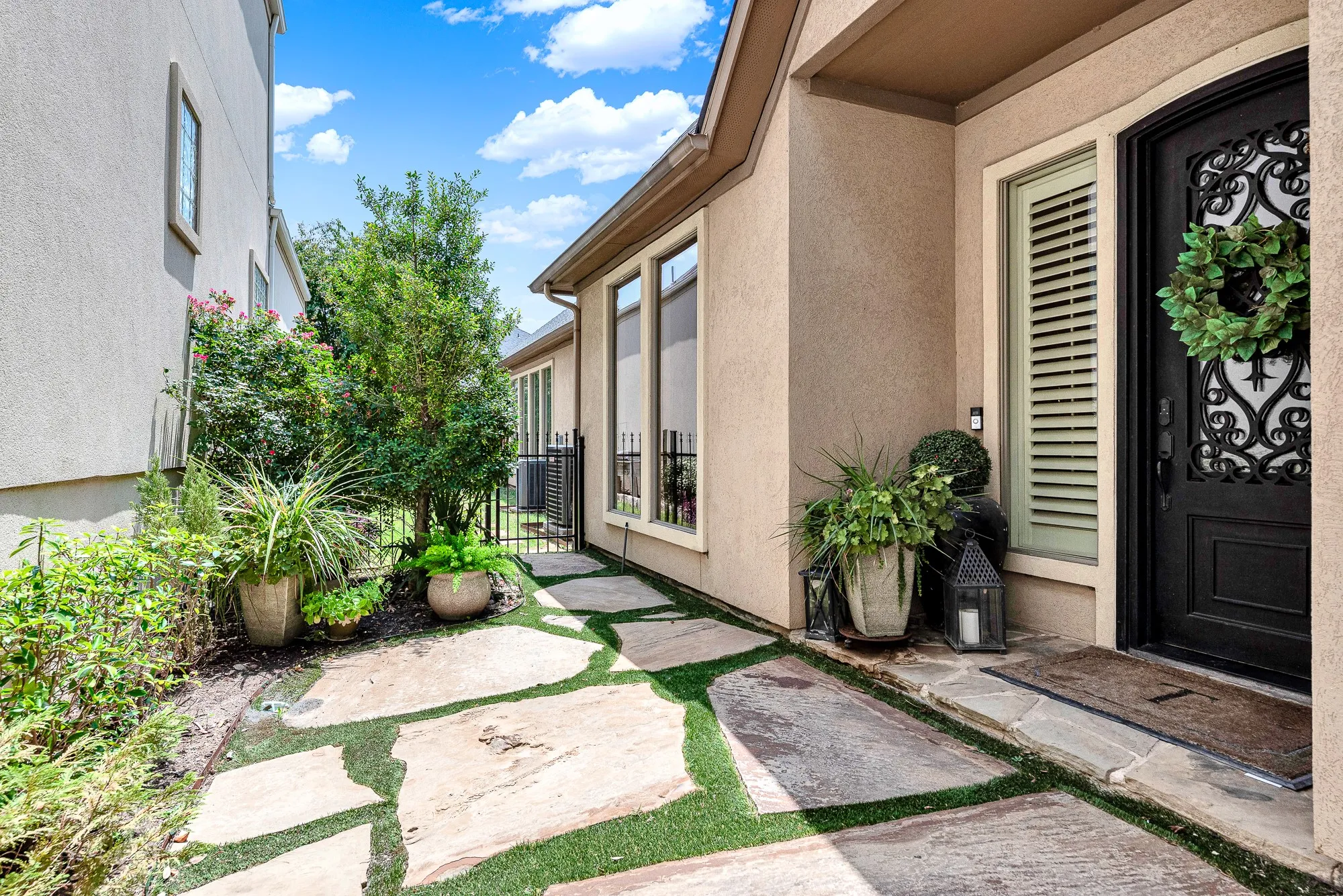 Large flagstones framed by lush green turf draw eyes straight toward the glass-and-iron front entry. Step outside on a calm morning with your warm mug to breathe in the fresh air in total privacy.