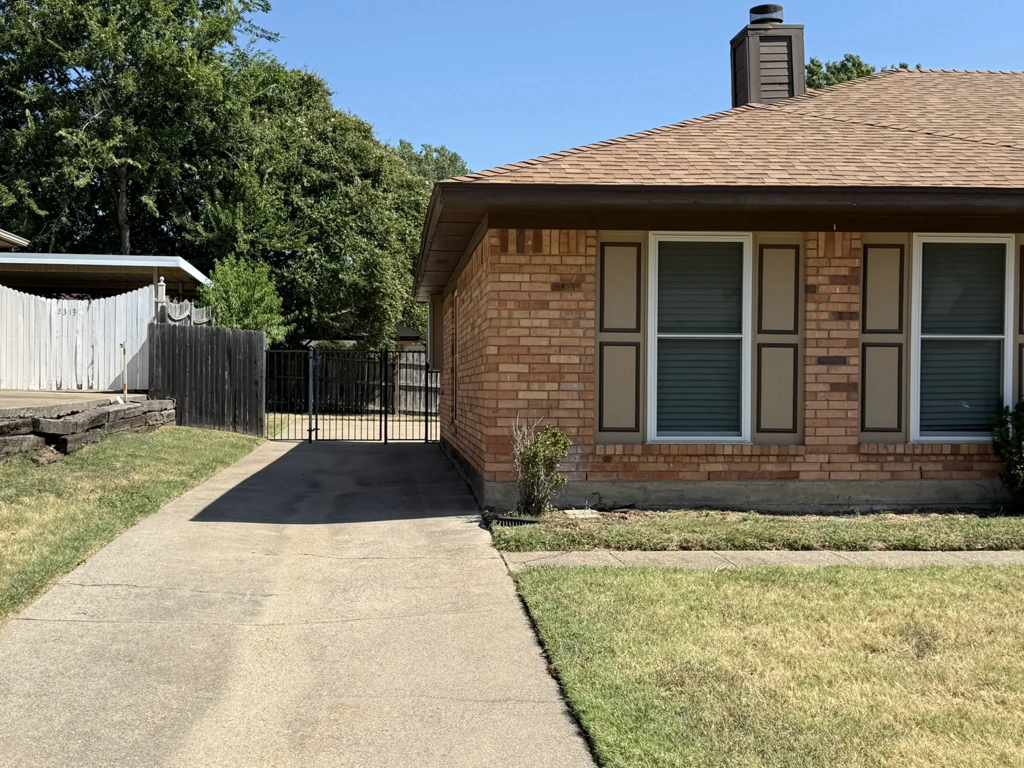 Brick exterior with decorative shutters and a gabled roofline