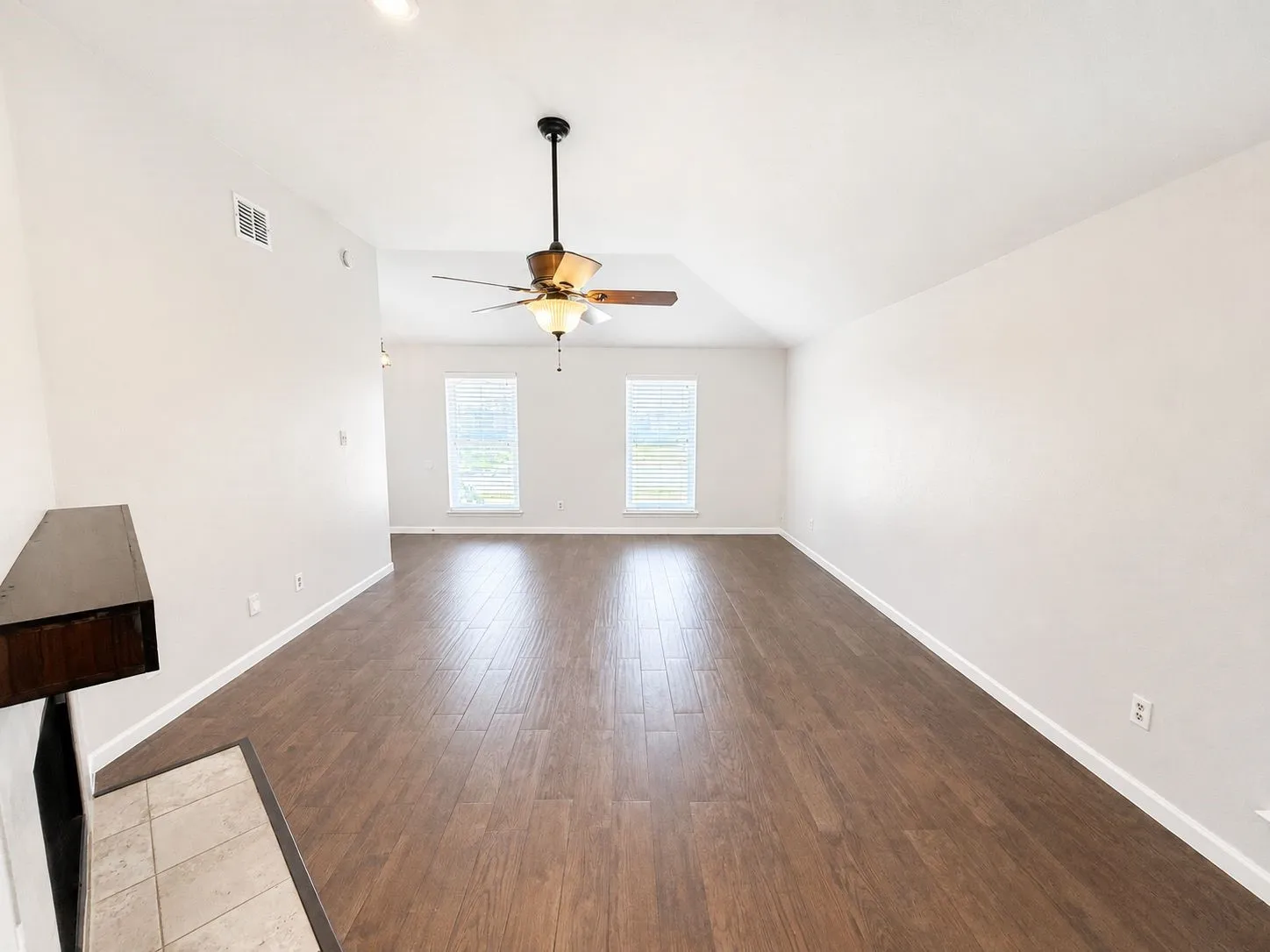 Vaulted ceilings with a ceiling fan, wood-finish flooring, recessed lighting, and two windows with blinds