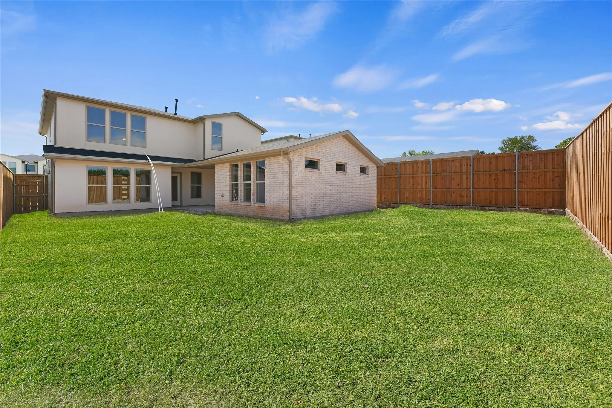 Expansive green lawn with a privacy fence