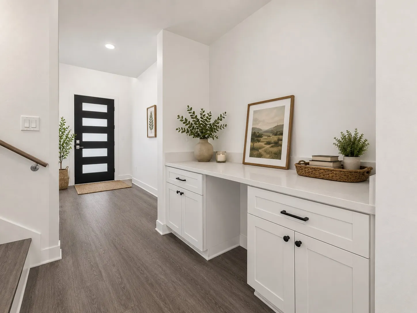 Modern entry door with frosted horizontal lites, wood-finish flooring, built-in white cabinetry, and a light-toned countertop