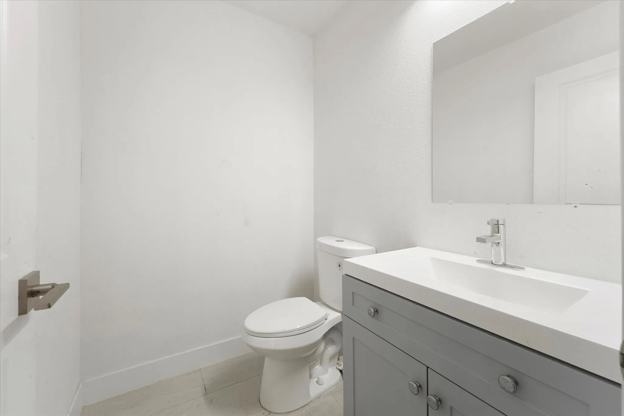Modern vanity with a rectangular integrated sink, chrome faucet, and gray cabinetry