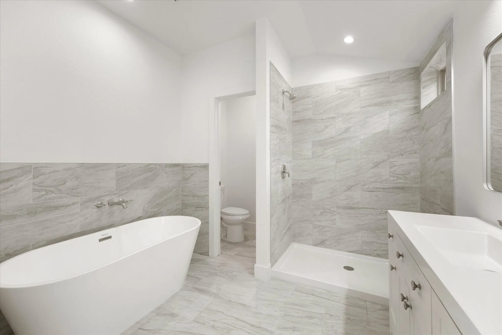 Freestanding soaking tub with wall-mounted fixtures