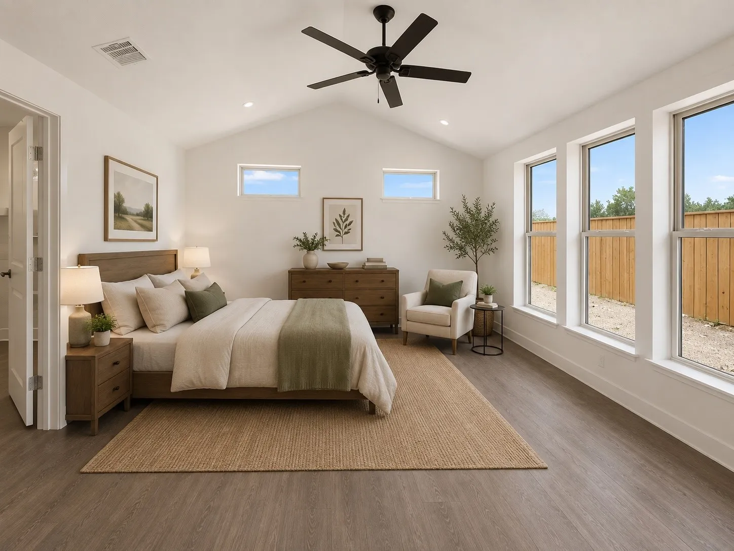 Vaulted ceiling with a black ceiling fan, wood-finish flooring, and multiple large windows
