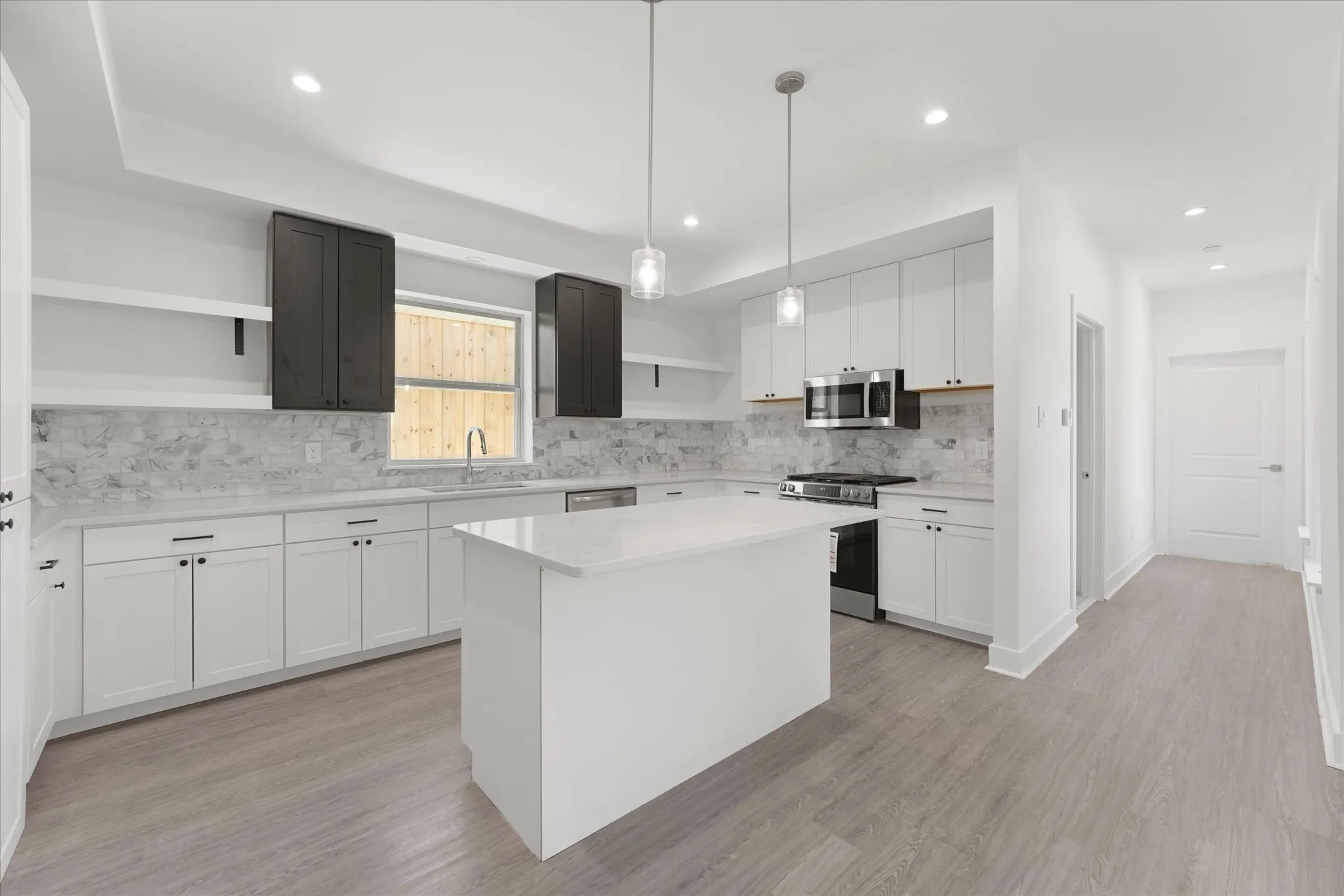 Kitchen featuring a central island, stainless steel appliances, recessed lighting, and pendant lighting fixtures