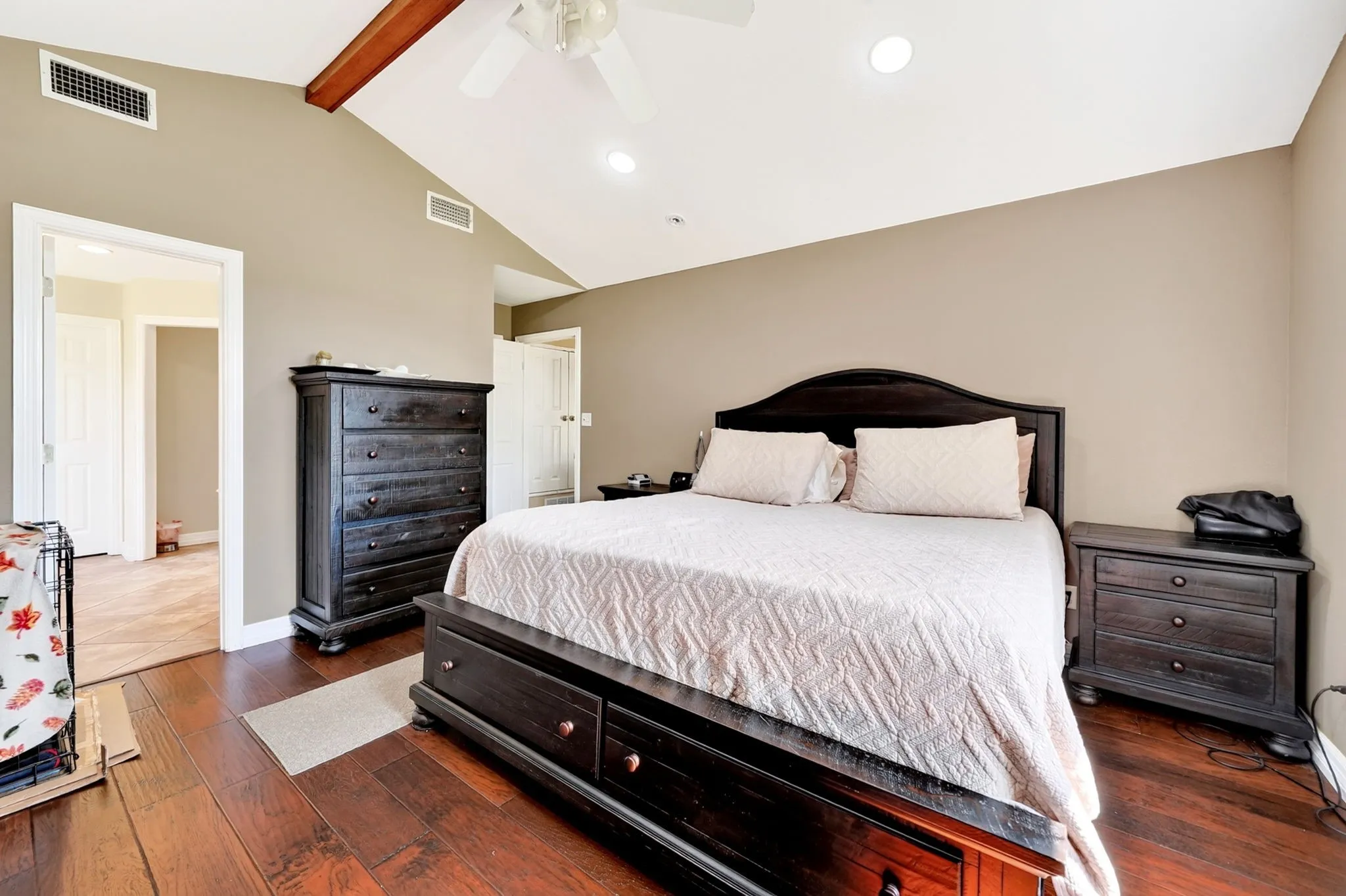 Vaulted ceiling with wood beam accent, recessed lighting, ceiling fan, and rich wood-finish flooring