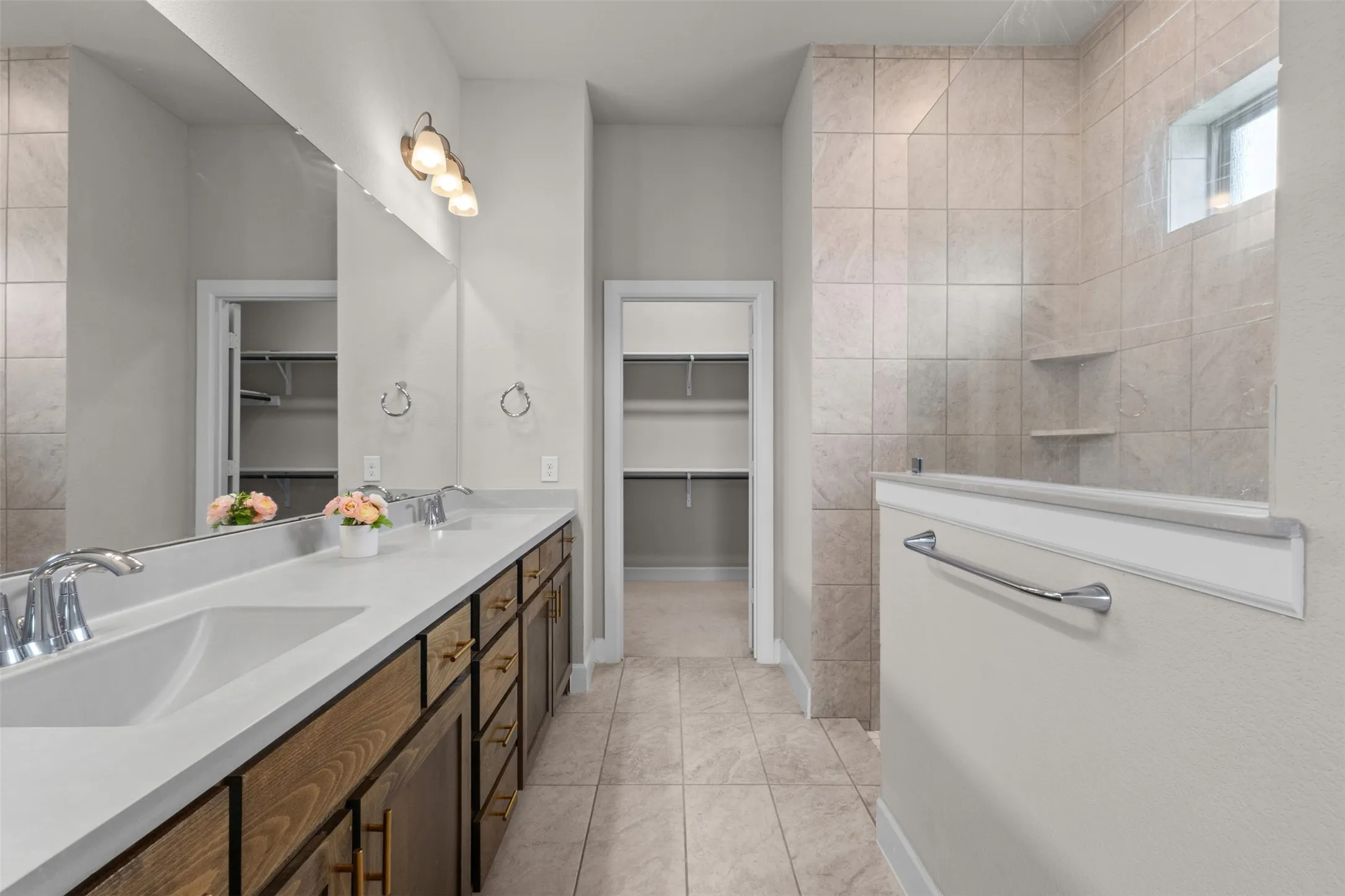Dual vanity with undermount sinks, wood-finish cabinetry, and brushed nickel hardware