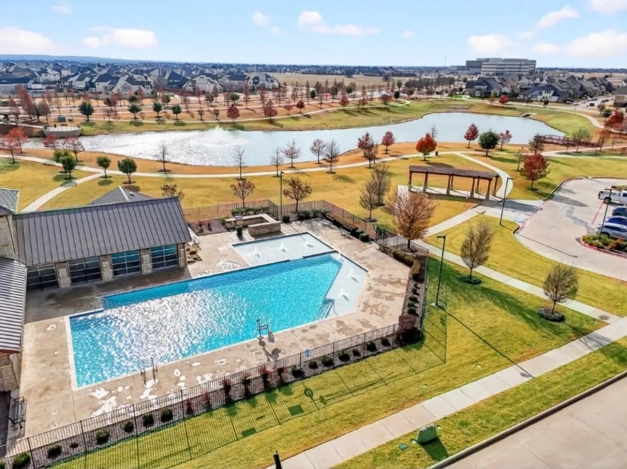 Community amenity center featuring a swimming pool, separate wading pool, and attached building with a metal roof