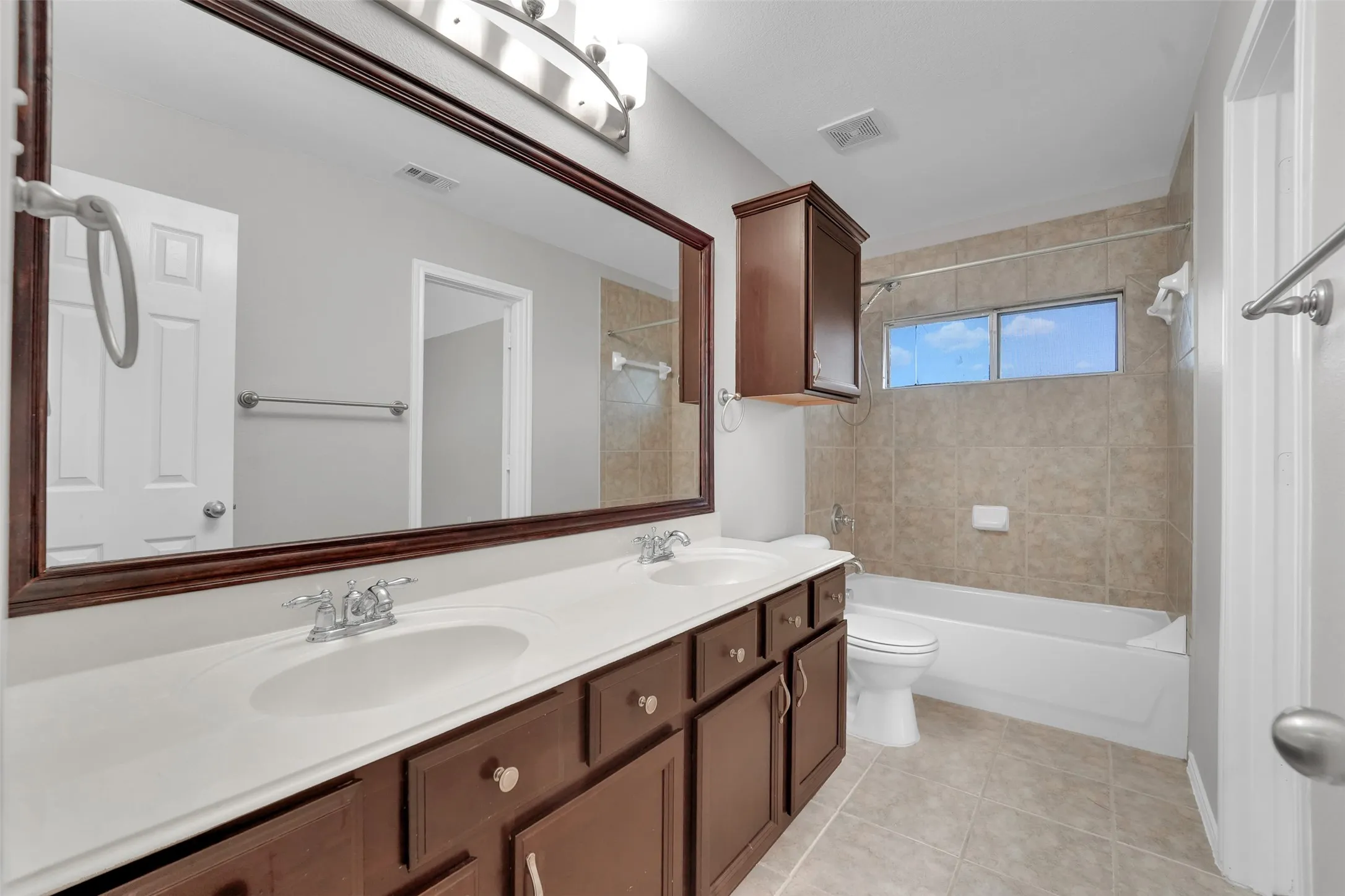 Double vanity with under-sink storage, integrated dual sinks, and a large framed mirror