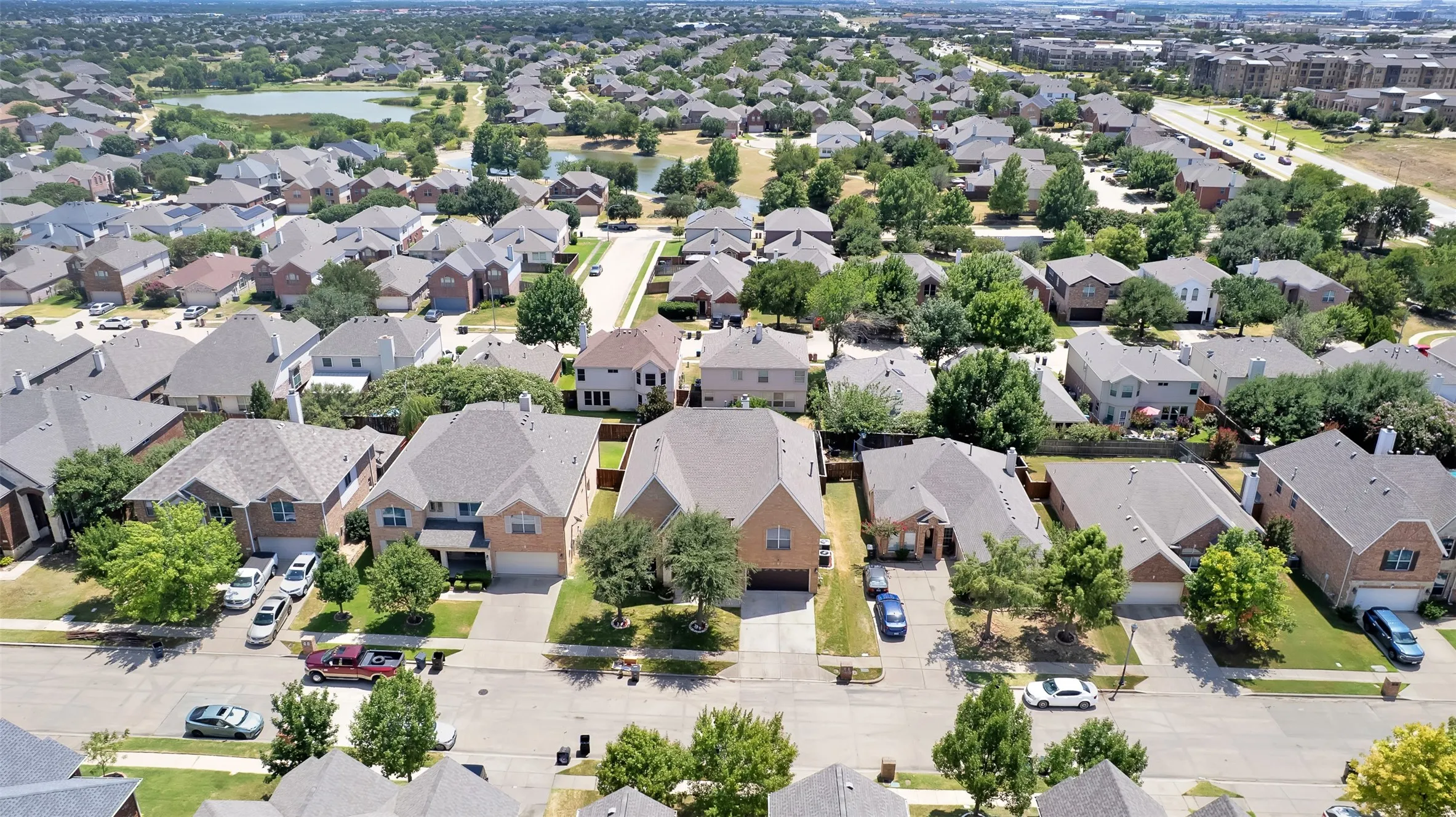 Aerial view showcasing a well-appointed residential community featuring single-family homes with spacious lots, mature landscaping throughout the neighborhood, and organized street layouts with ample driveway parking