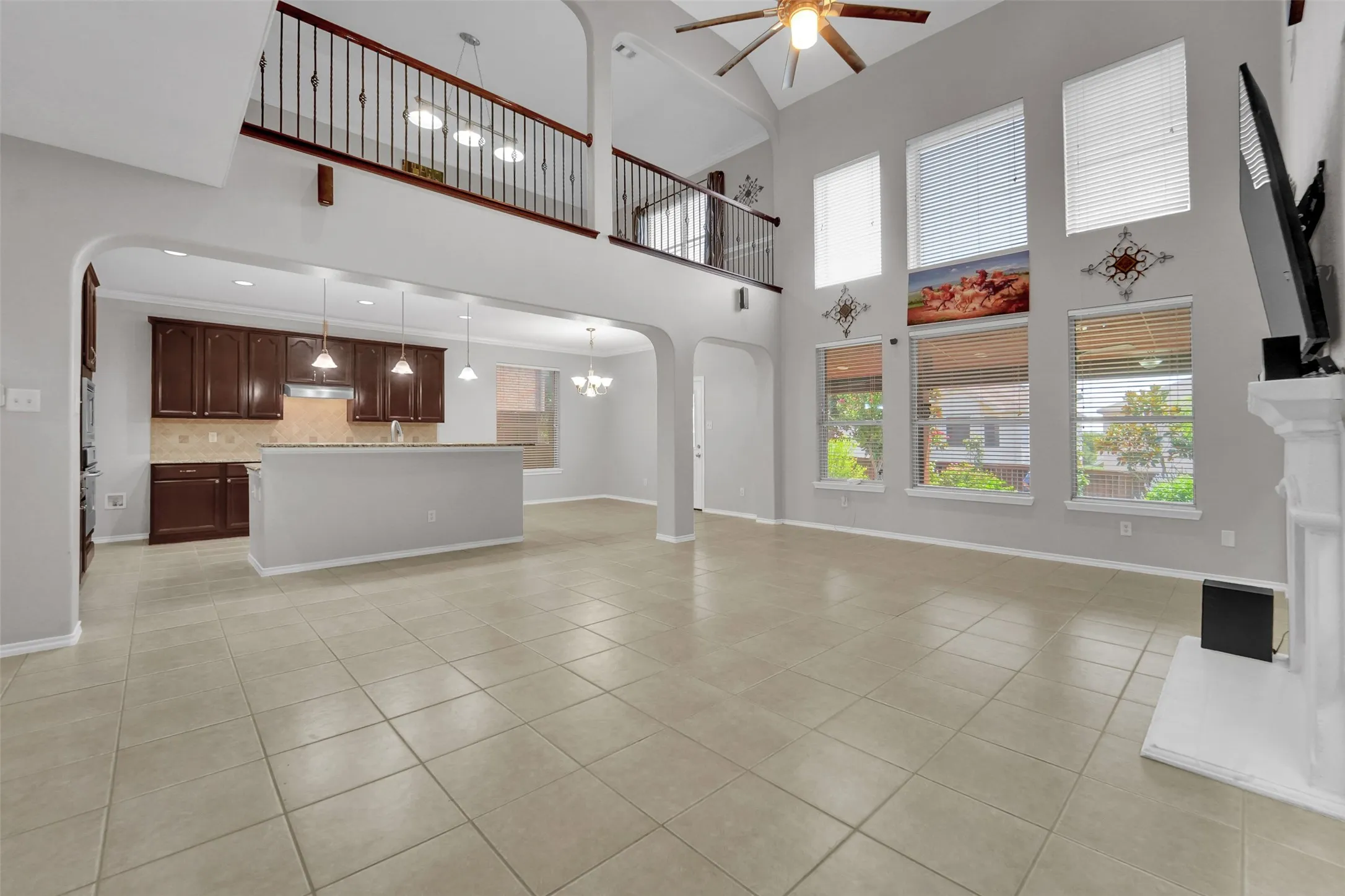 Two-story great room with vaulted ceiling, tile flooring, and a fireplace