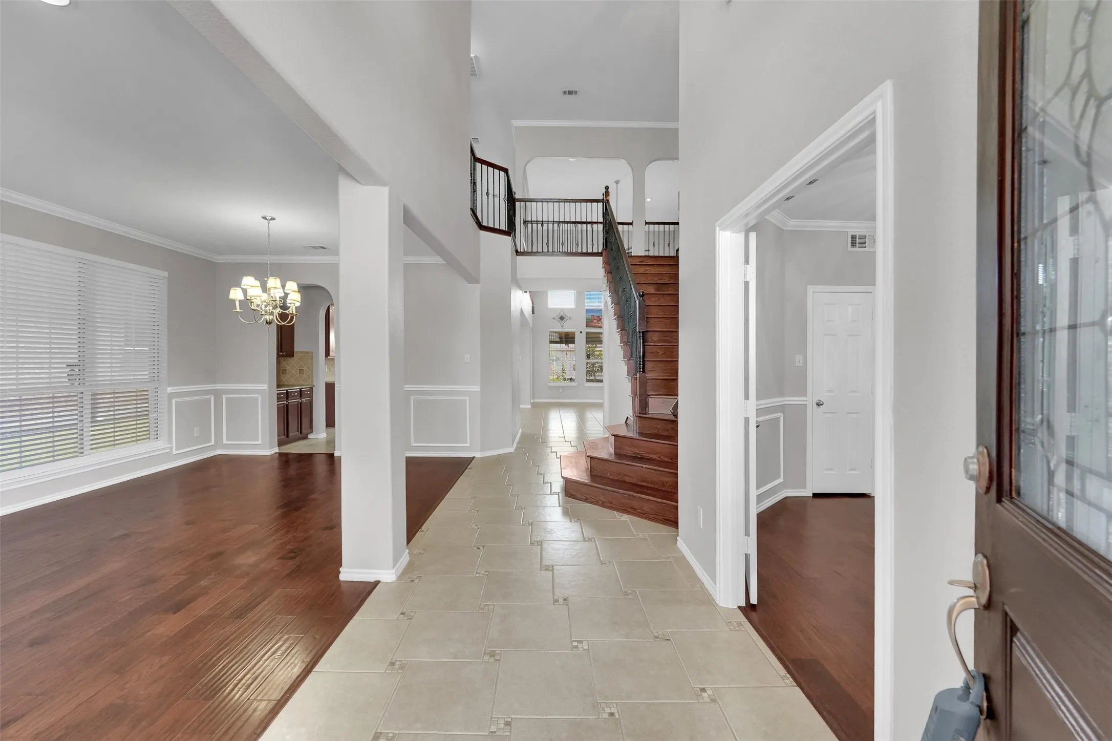 Two-story foyer with a grand staircase and wrought iron balusters
