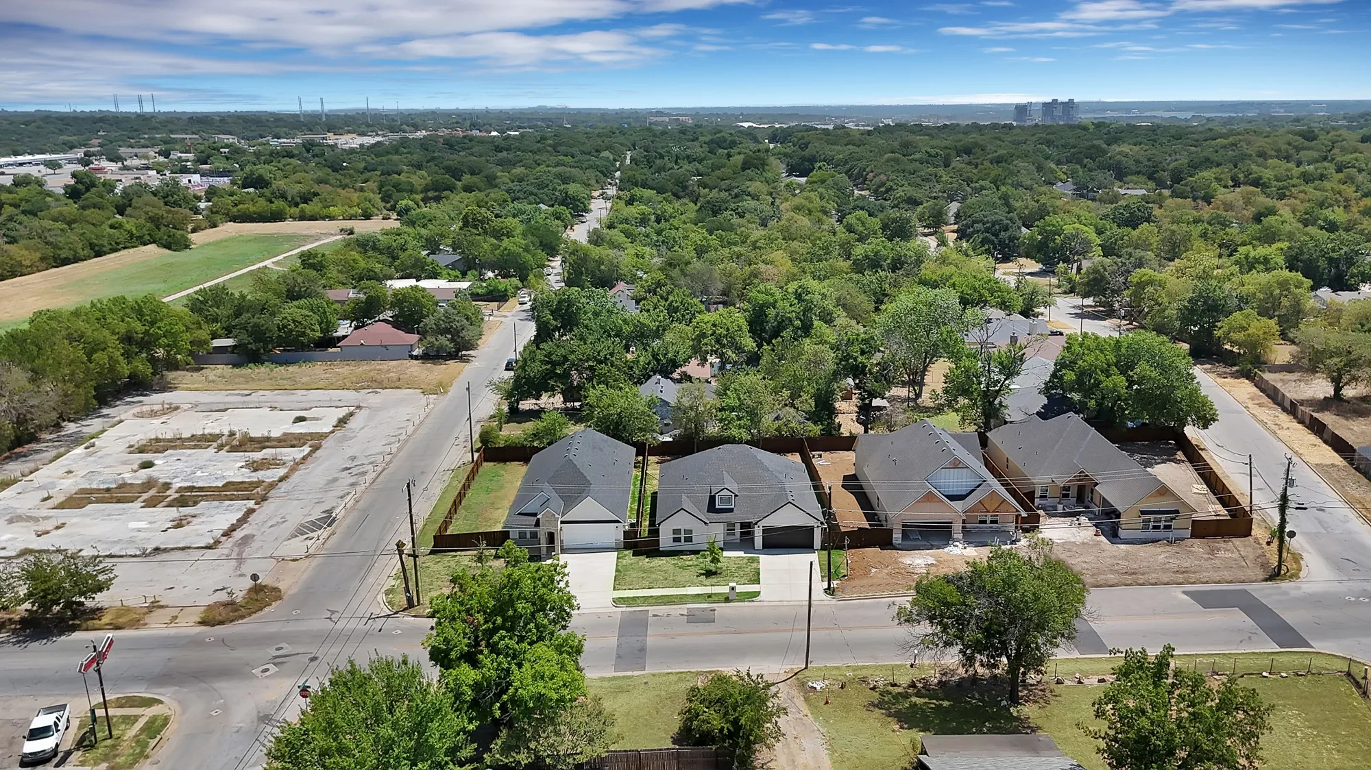 Aerial perspective of residential properties with mature trees and a distant cityscape