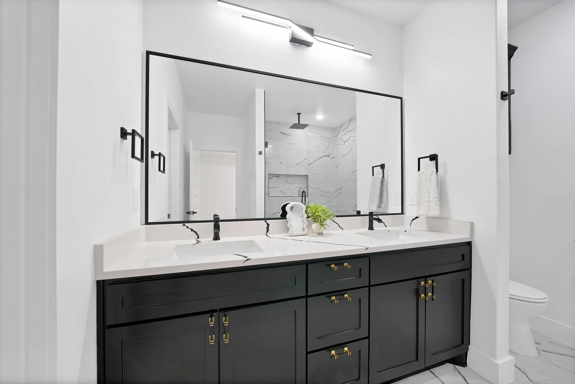 Dual vanity with black cabinetry, white countertops, and integrated rectangular sinks
