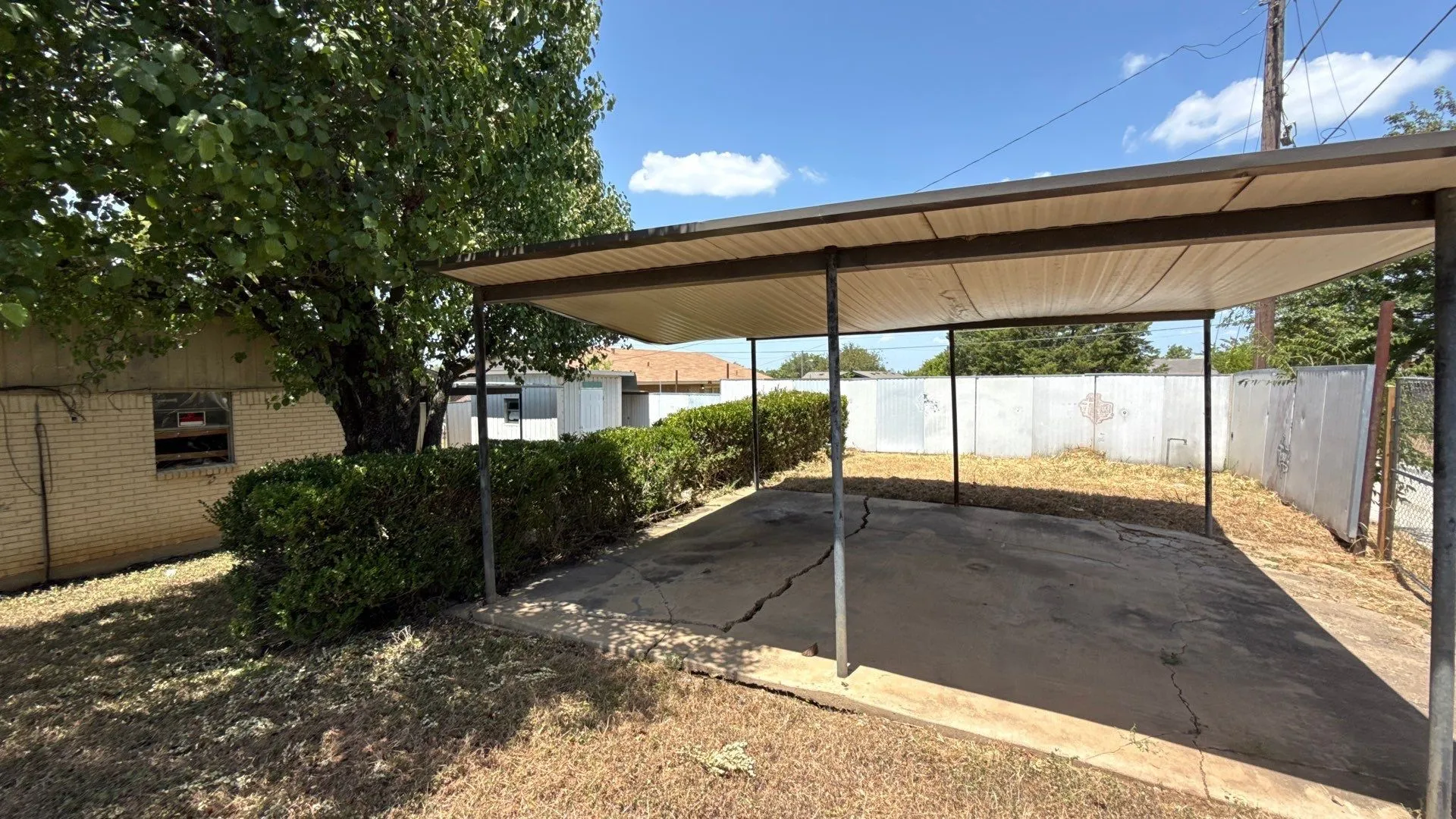 Carport structure with a metal roof and concrete slab