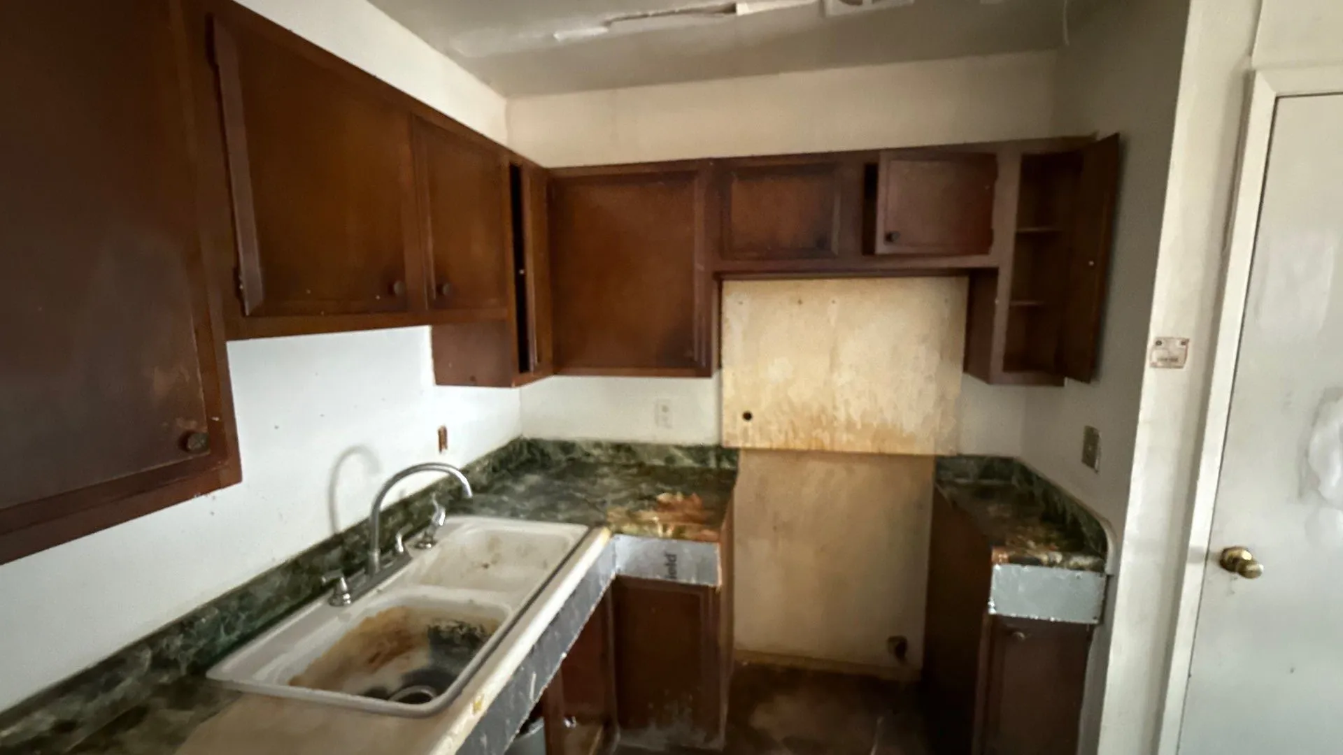 Kitchen featuring wood-finish cabinetry, a double-basin sink, and a counter-level faucet