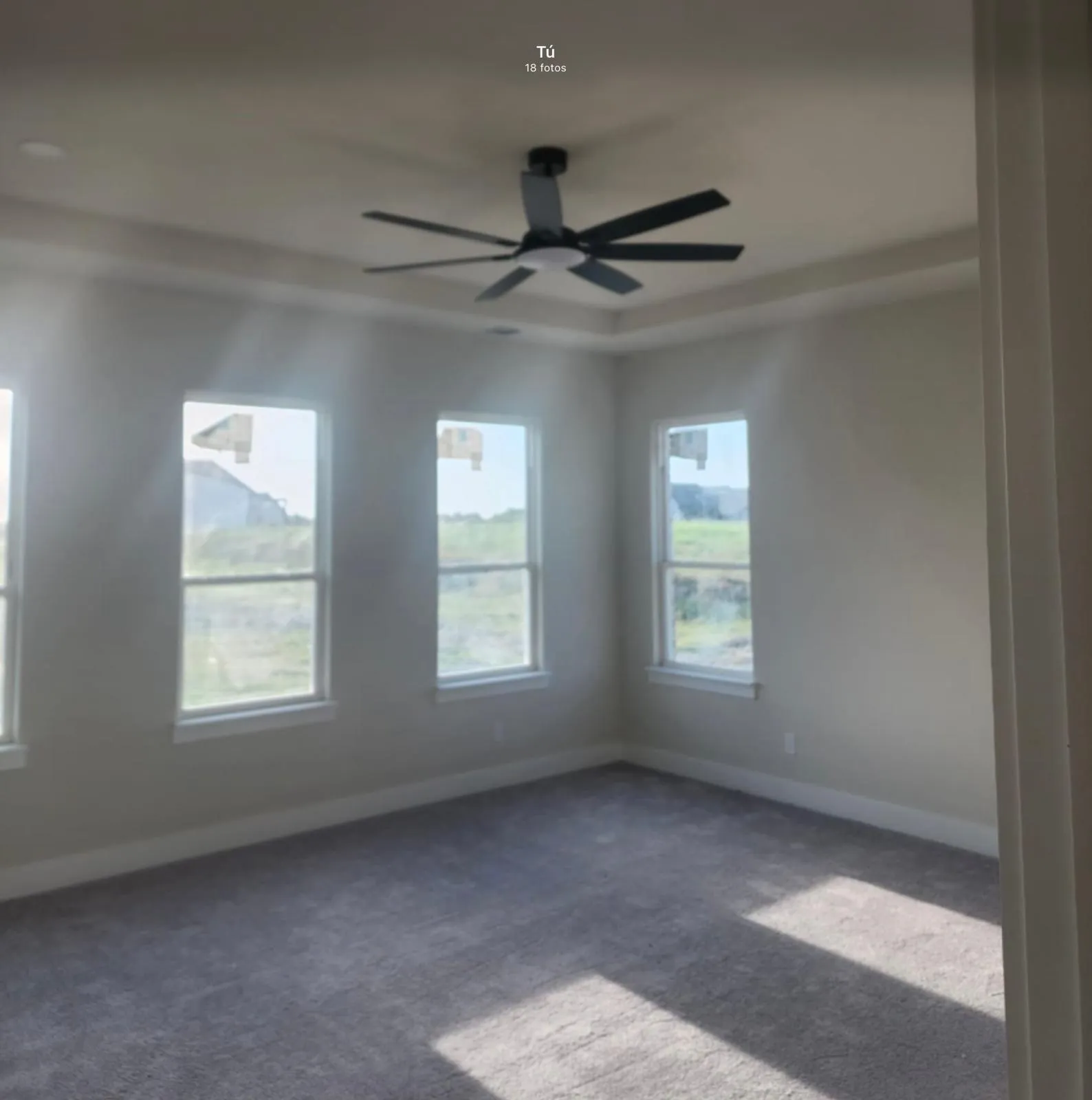 Tray ceiling with a contemporary ceiling fan, recessed lighting, and multiple windows