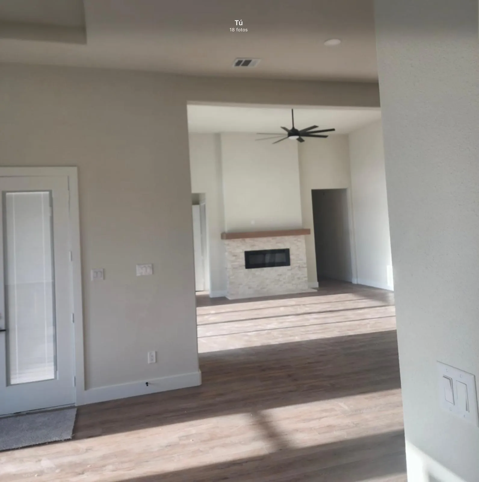 Open-concept living space featuring wood-finish flooring, neutral wall finishes, and abundant natural light