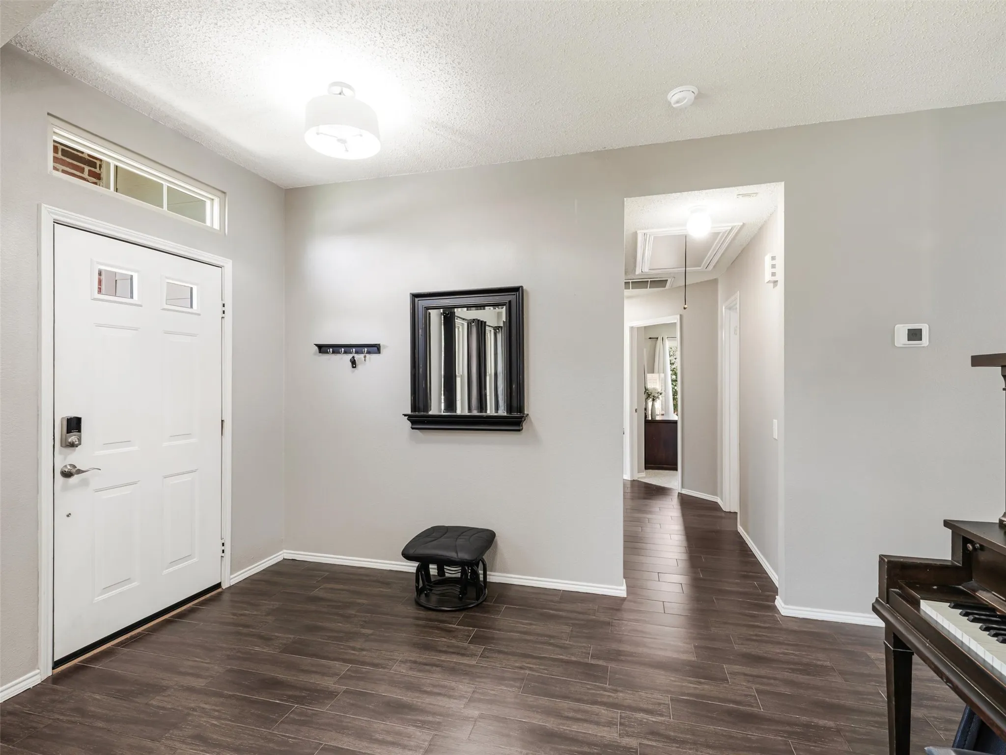 Recessed lighting, wood-finish flooring, white paneled door with glass inserts, transom window, contemporary flush-mount light fixture