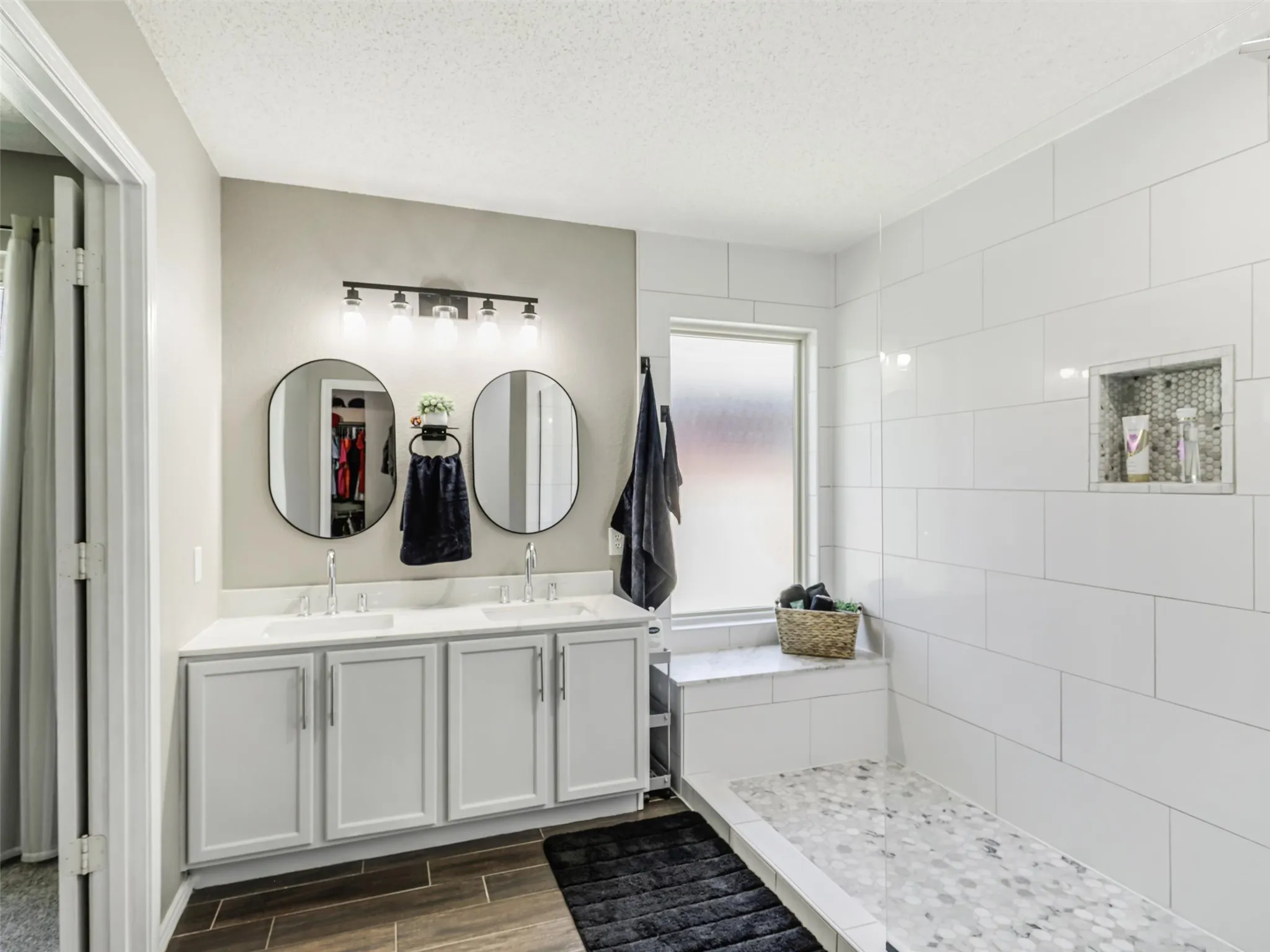 Double vanity with dual sinks, framed mirrors, and contemporary lighting