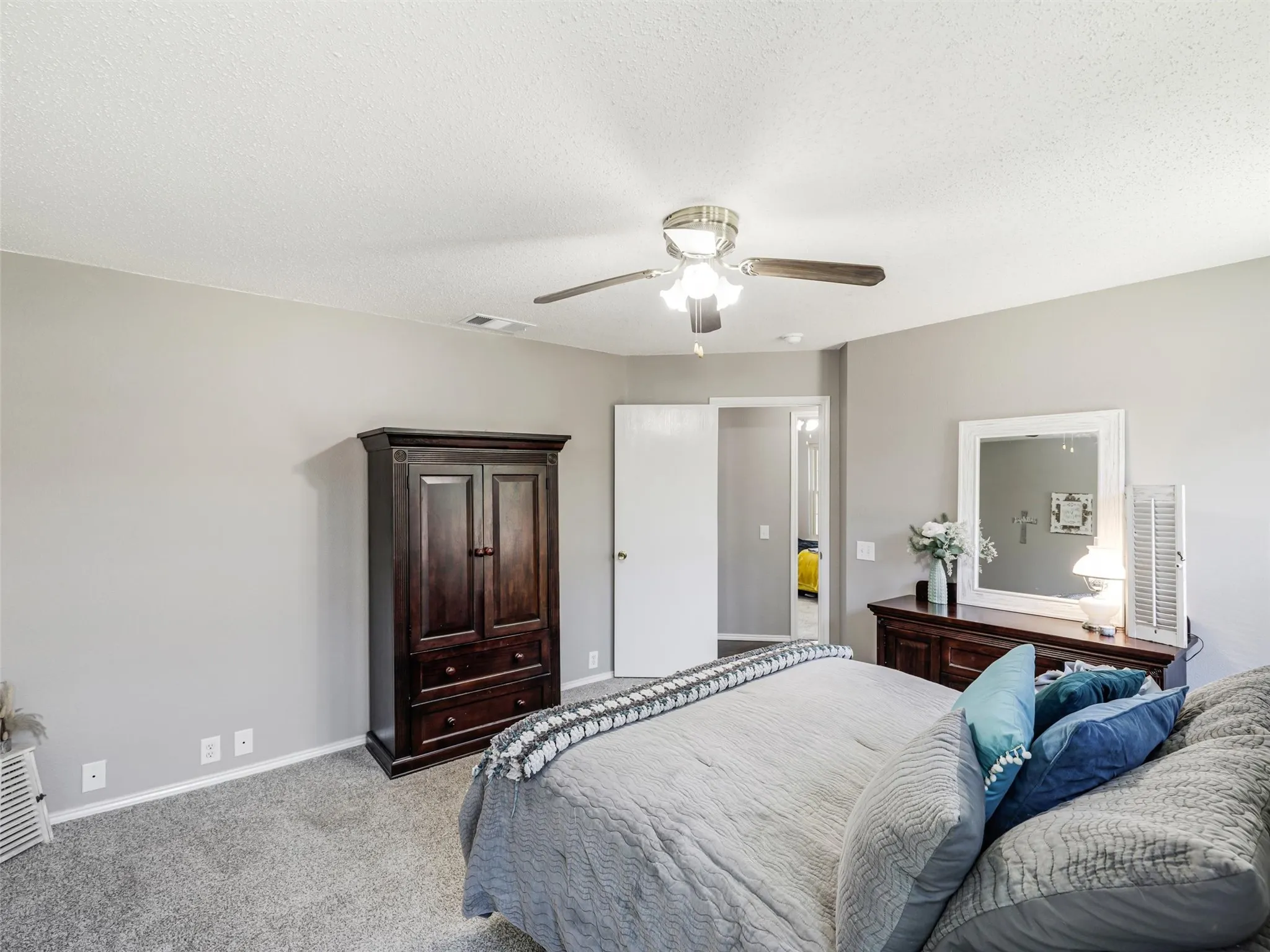 Recessed lighting, ceiling fan with light fixture, light gray wall paint, gray carpet flooring, white trim