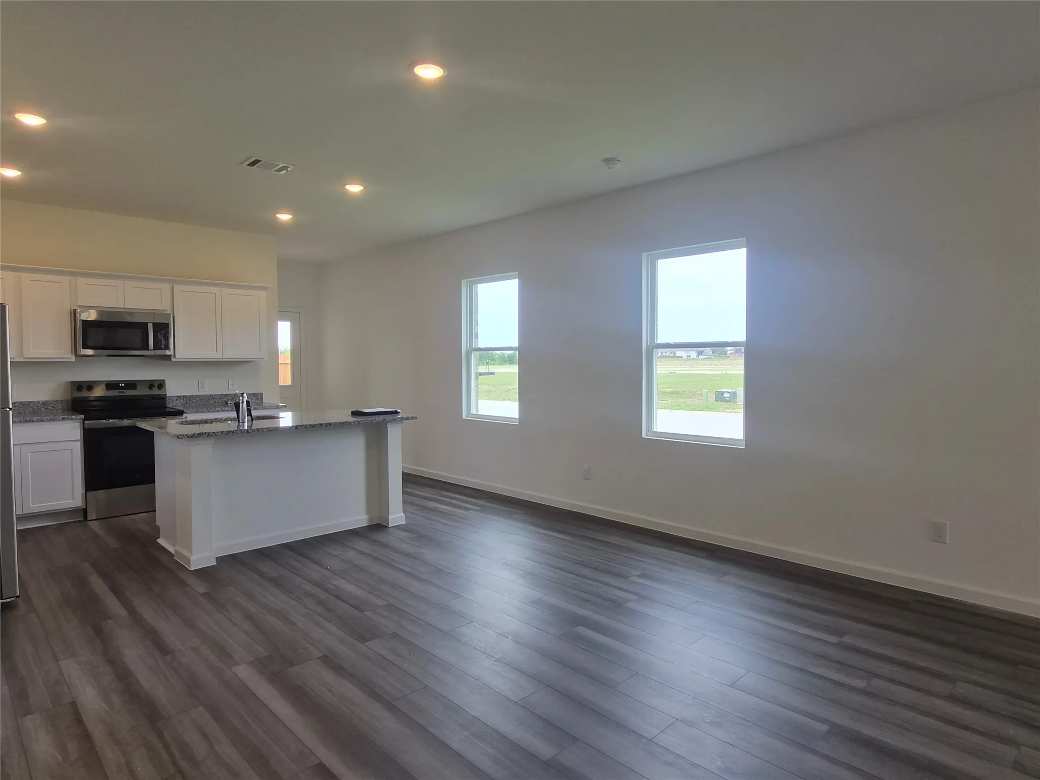 Open concept living area featuring wood-finish flooring, recessed lighting, and white walls