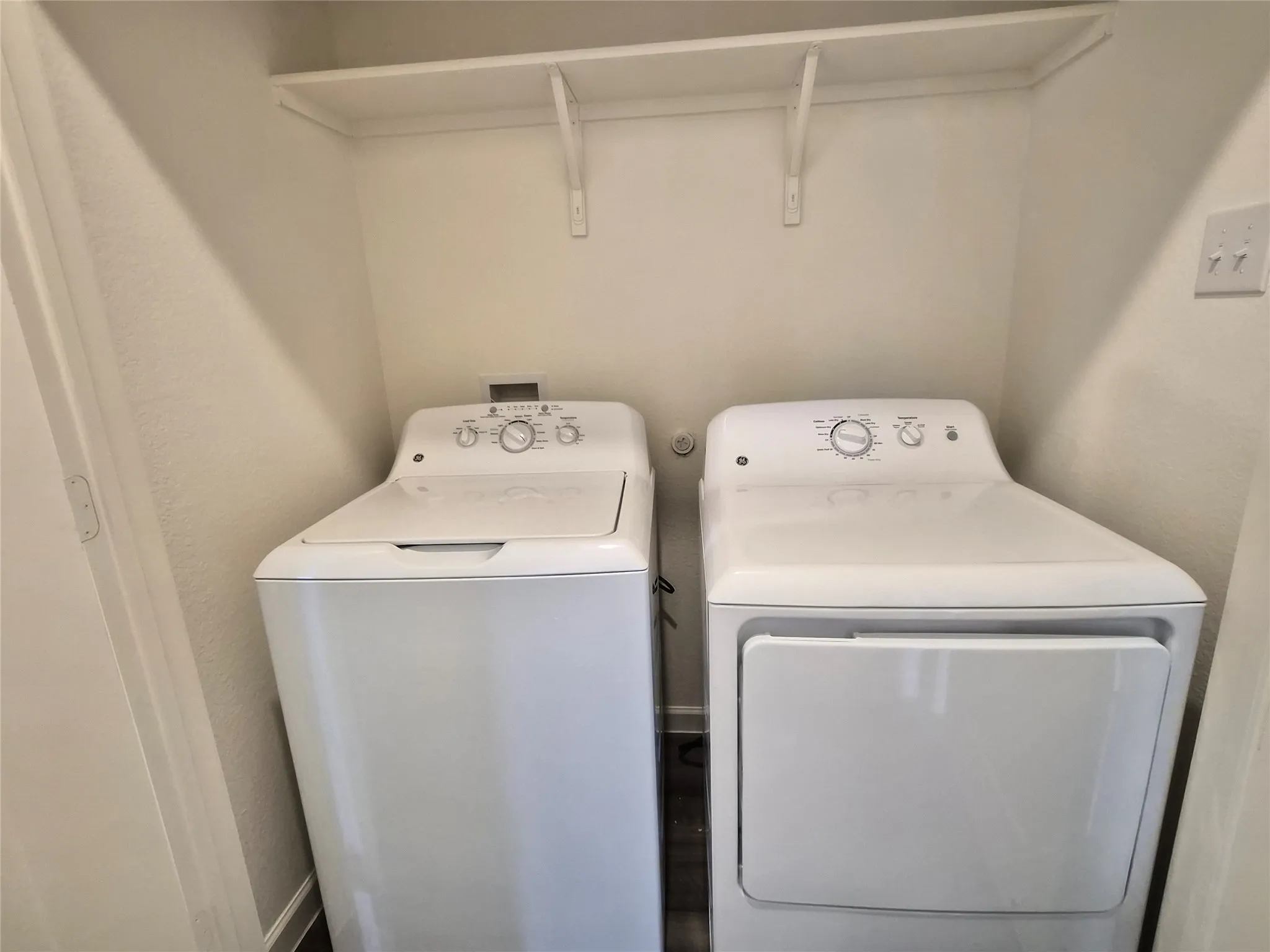 Dedicated laundry area featuring a white washing machine and dryer