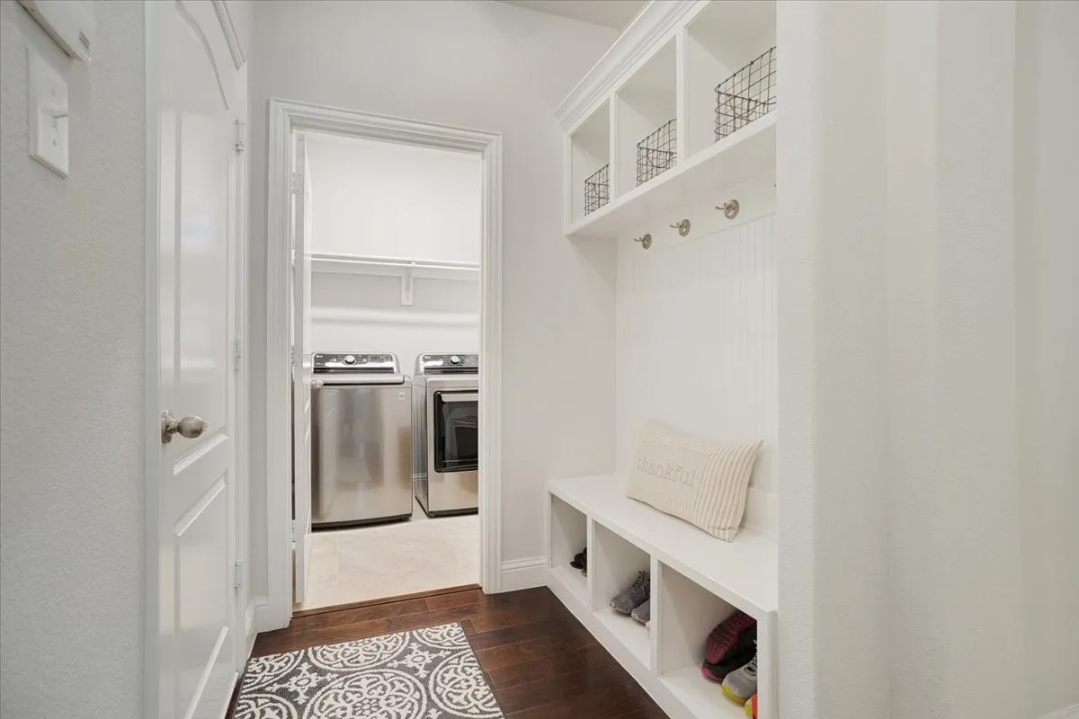Built-in mudroom bench with cubby storage, integrated coat hooks, and upper open shelving